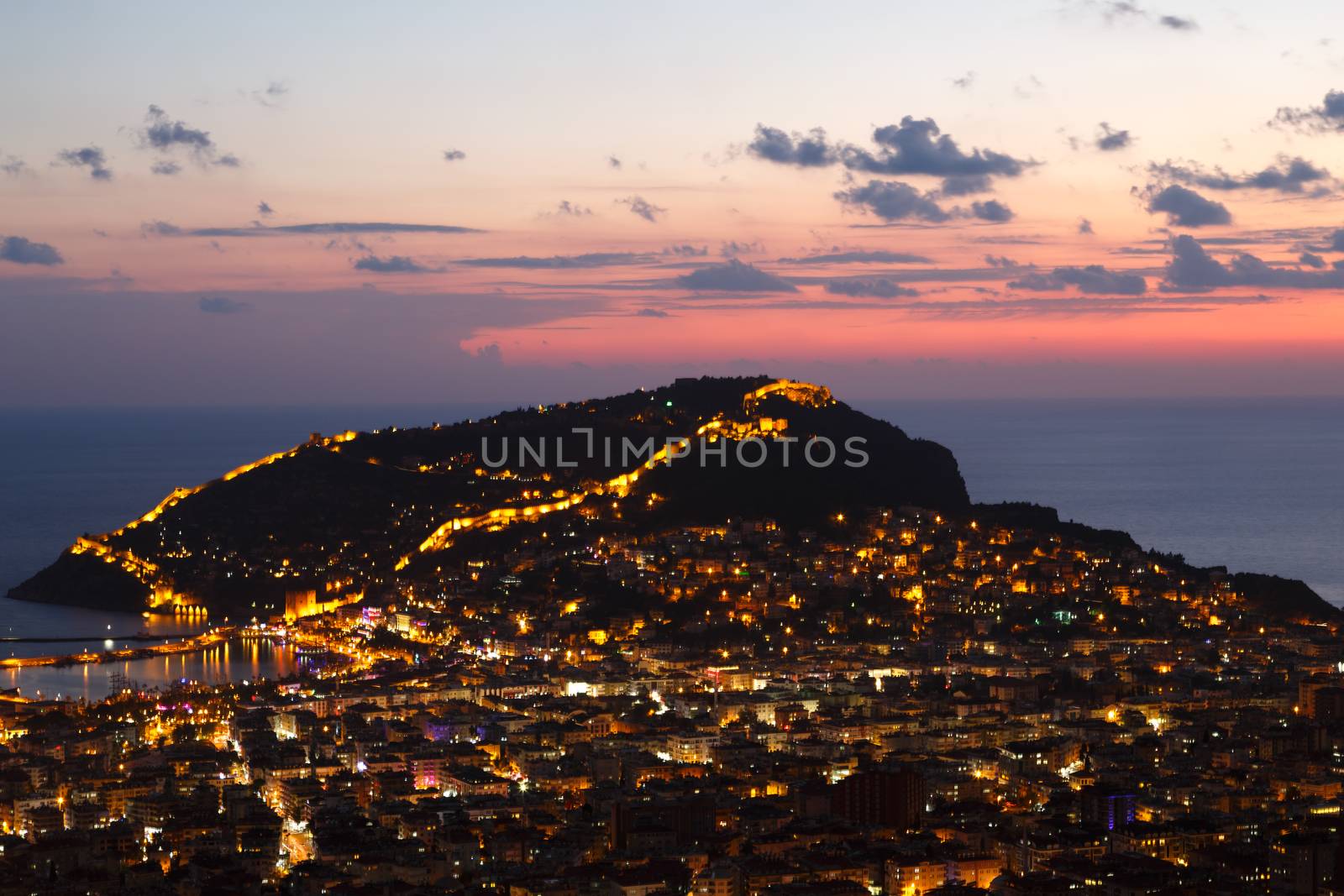 Night view of peninsula in Antalya, Alanya Castle with lighting in blue hours.