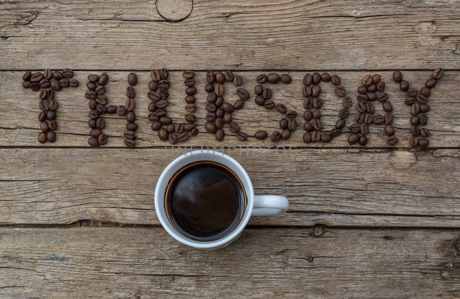 Cup of coffee on wooden background and THURSDAY coffee beans  by radzonimo