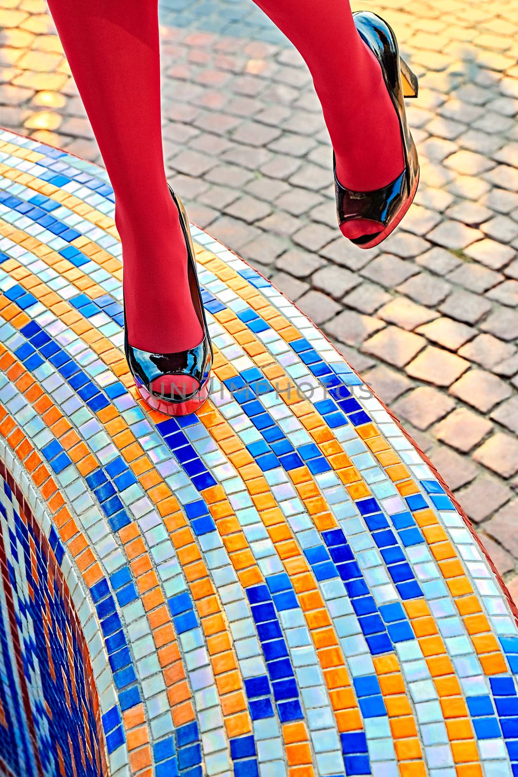 Fashion urban womens legs, pantyhose, stylish heels. Multicolored geometry square mosaic. Trendy shoes, creative, outdoor