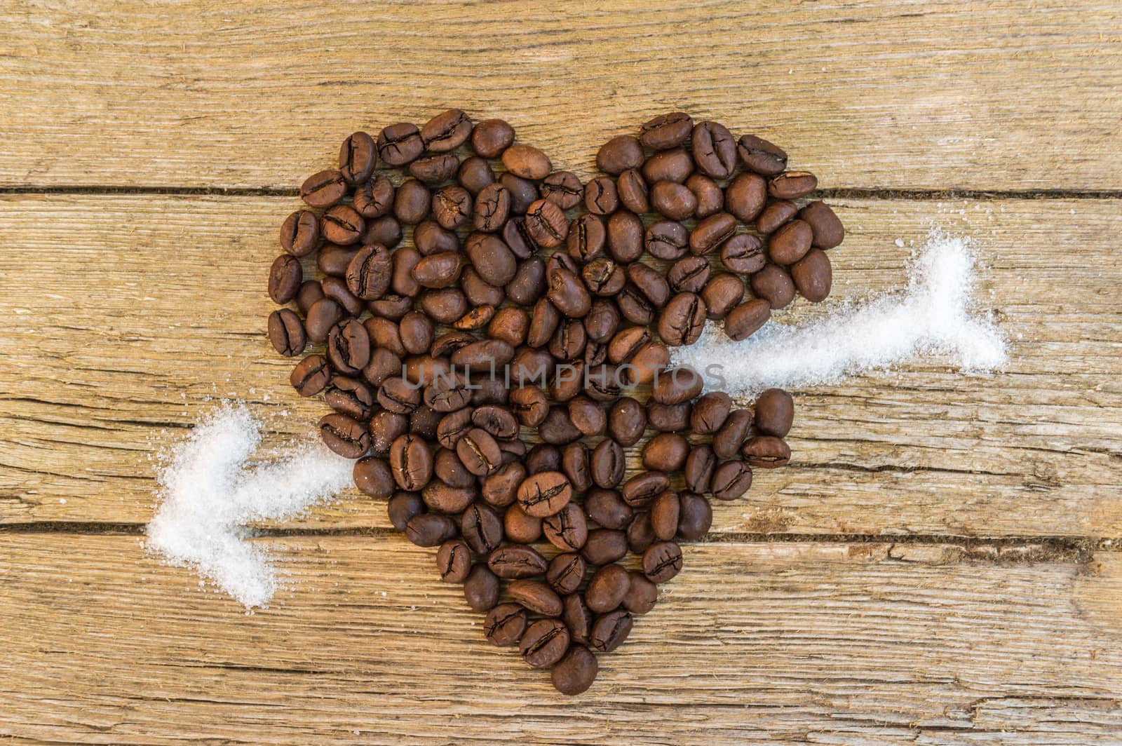 Coffee beans heart stabbed by white sugar on wooden background  by radzonimo