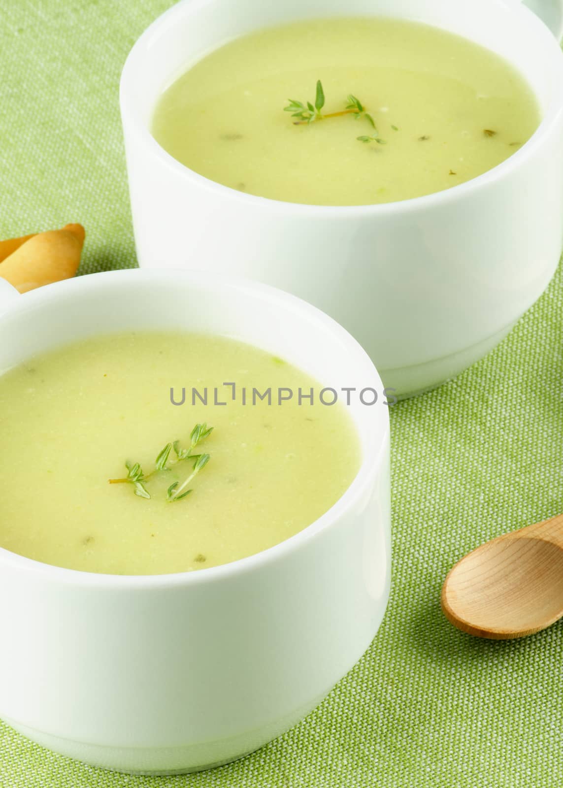 Delicious Cream Asparagus Soup in Two White Soup Cups Cross Section on Green Napkin