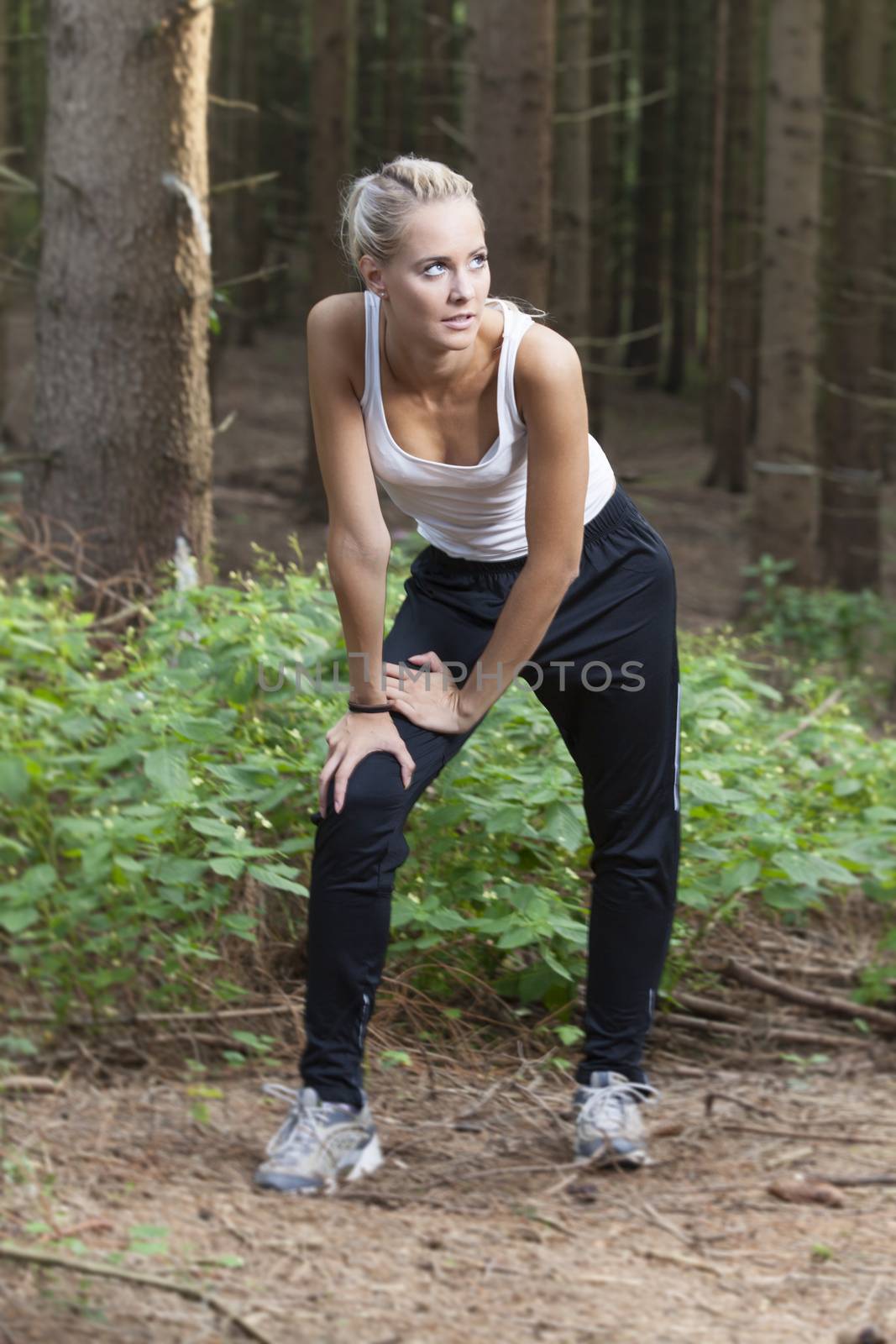 blonde woman stretching in the woods