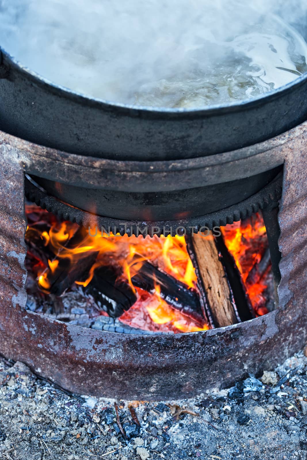 Preparing food on big pot, outside on wooden fire