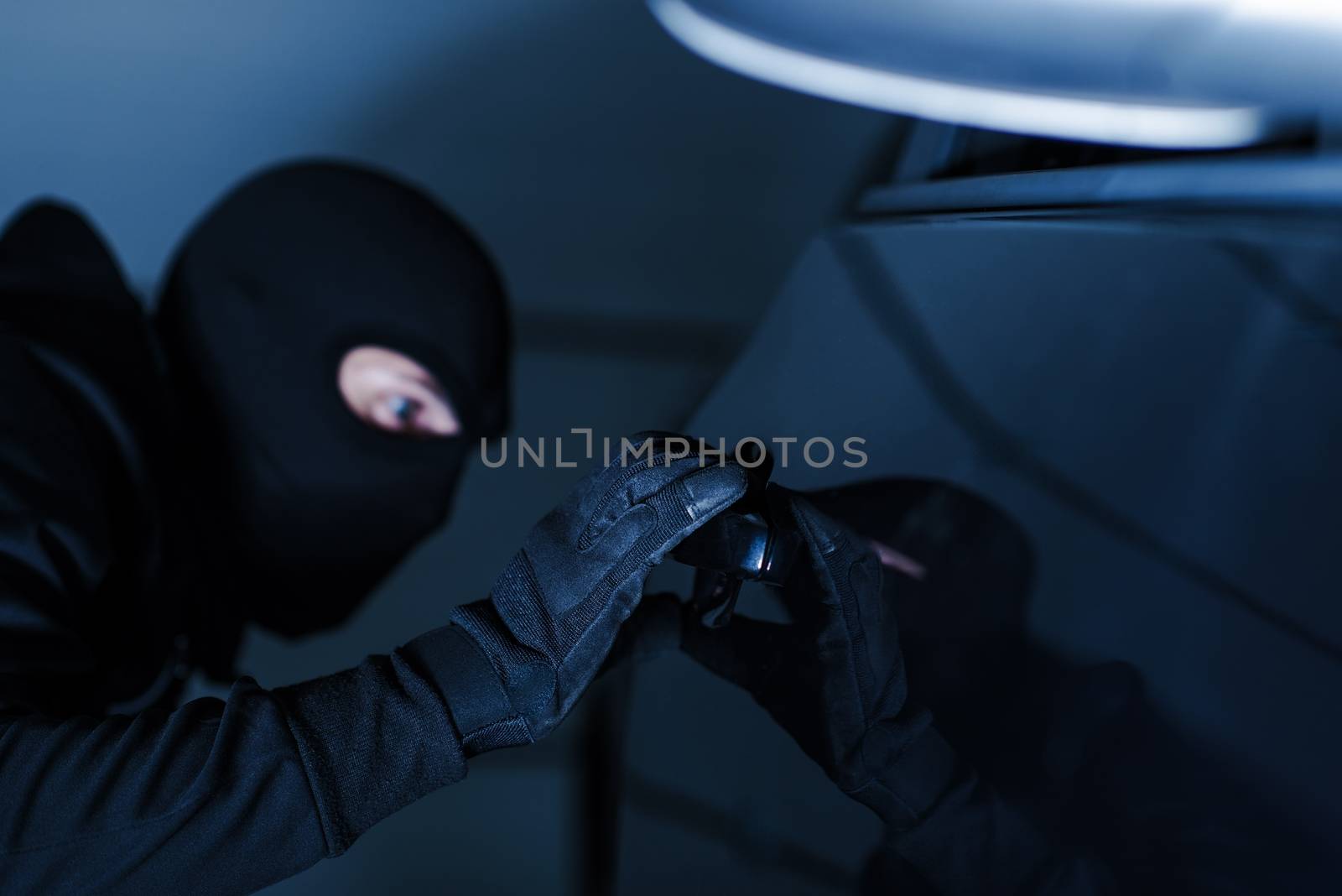 Motor Vehicle Theft Photo Concept. Car Theft in Black Gloves Stealing a Car.