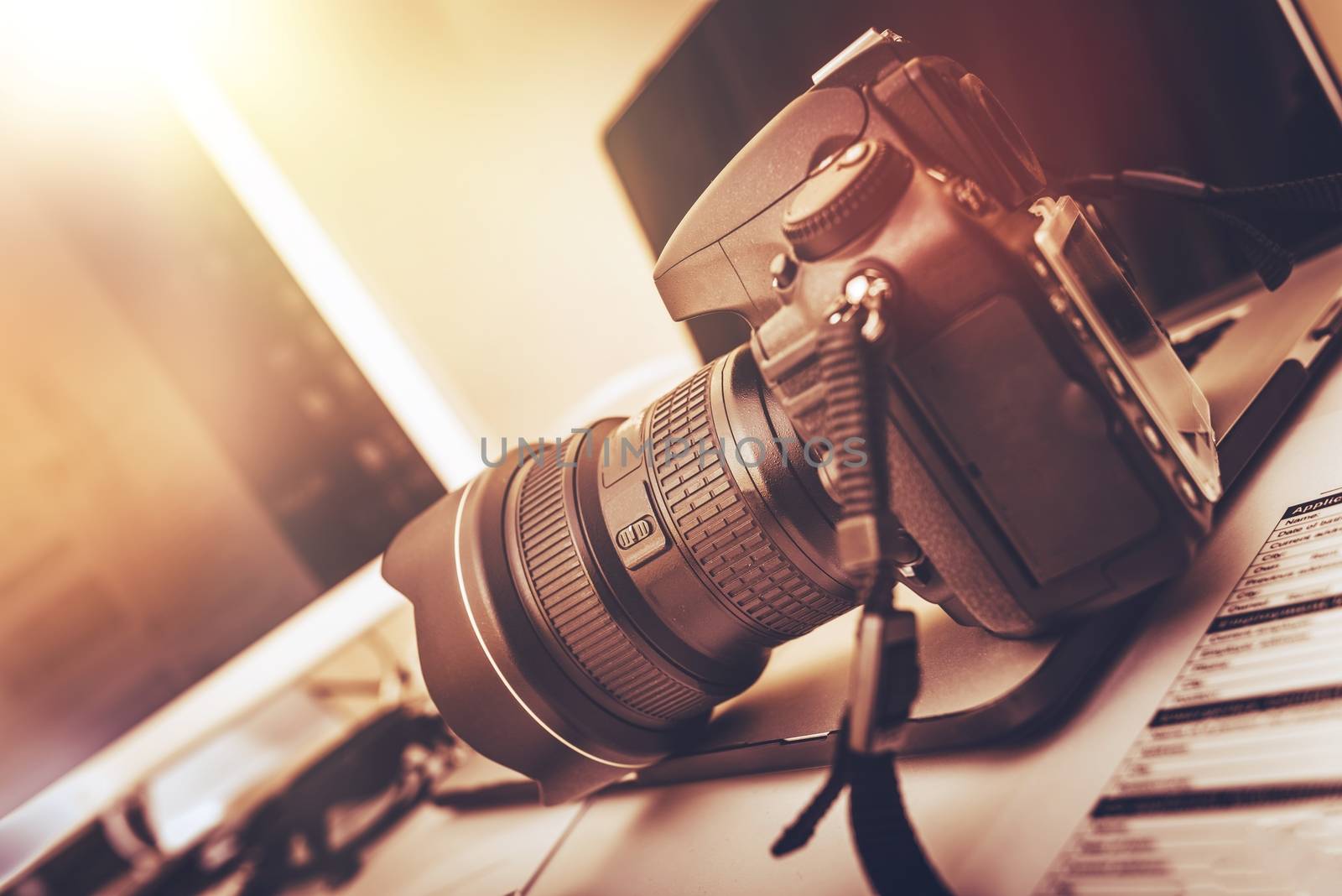 Digital Photography Workstation. Modern Digital DSLR Camera, Laptop Computer and Display.