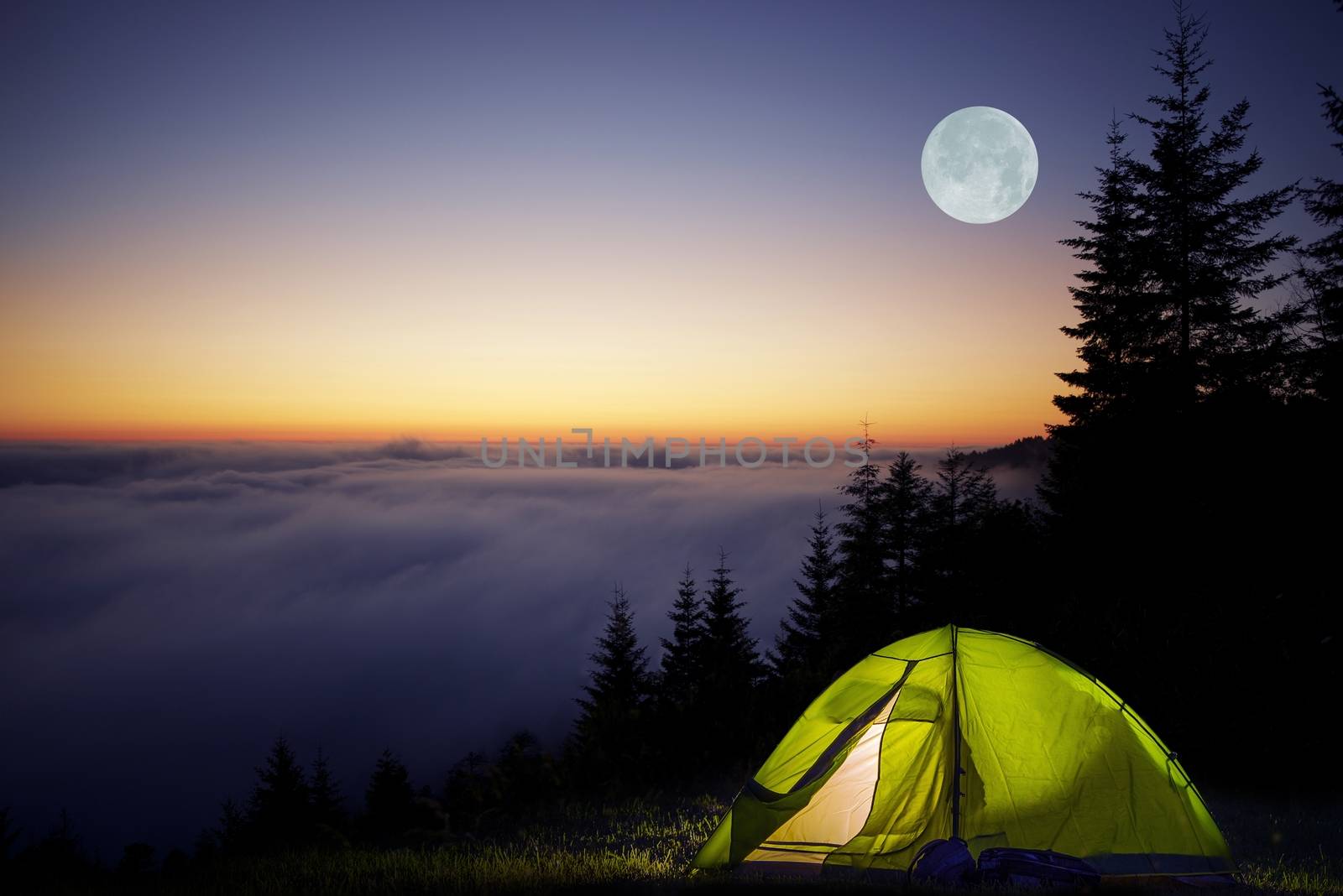 Tent Camping in a Forest During Full Moon Night. Foggy Mountains Camping.
