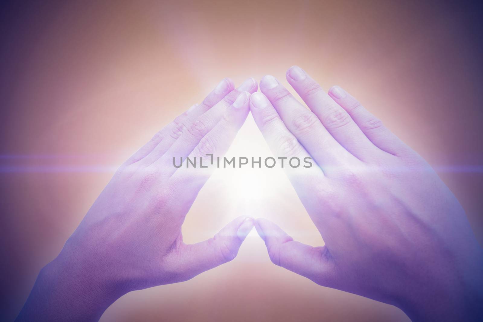 Woman making heart shape with hands against orange background