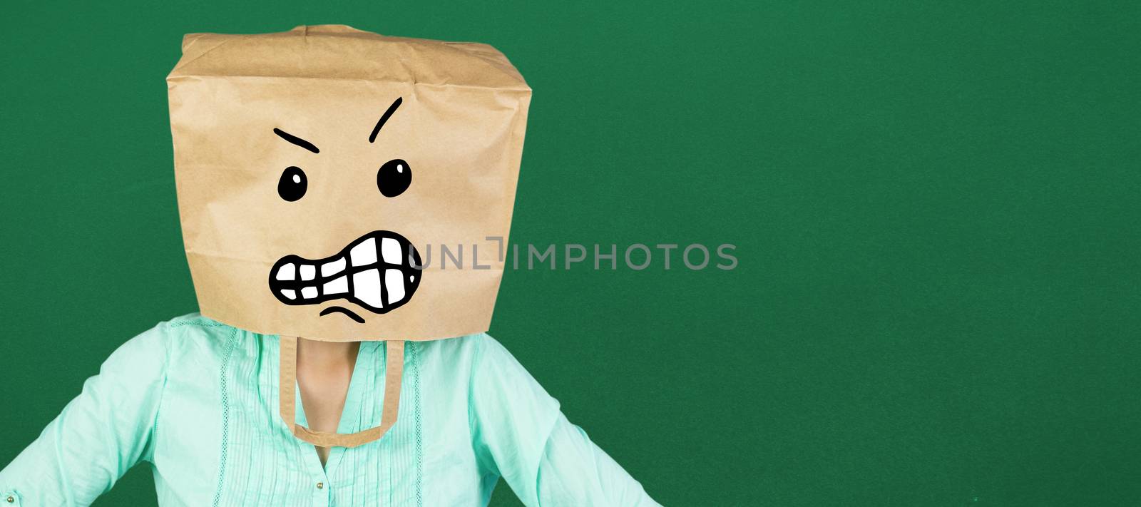 Woman covering head with brown paper bag  against green