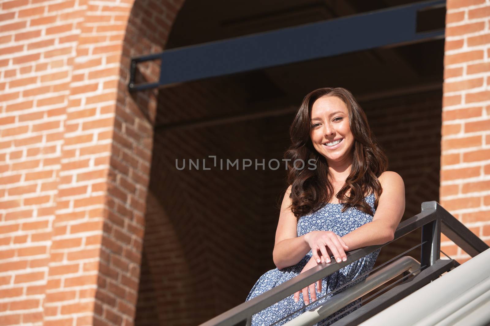 Smiling Caucasian female leaning on railing outdoors