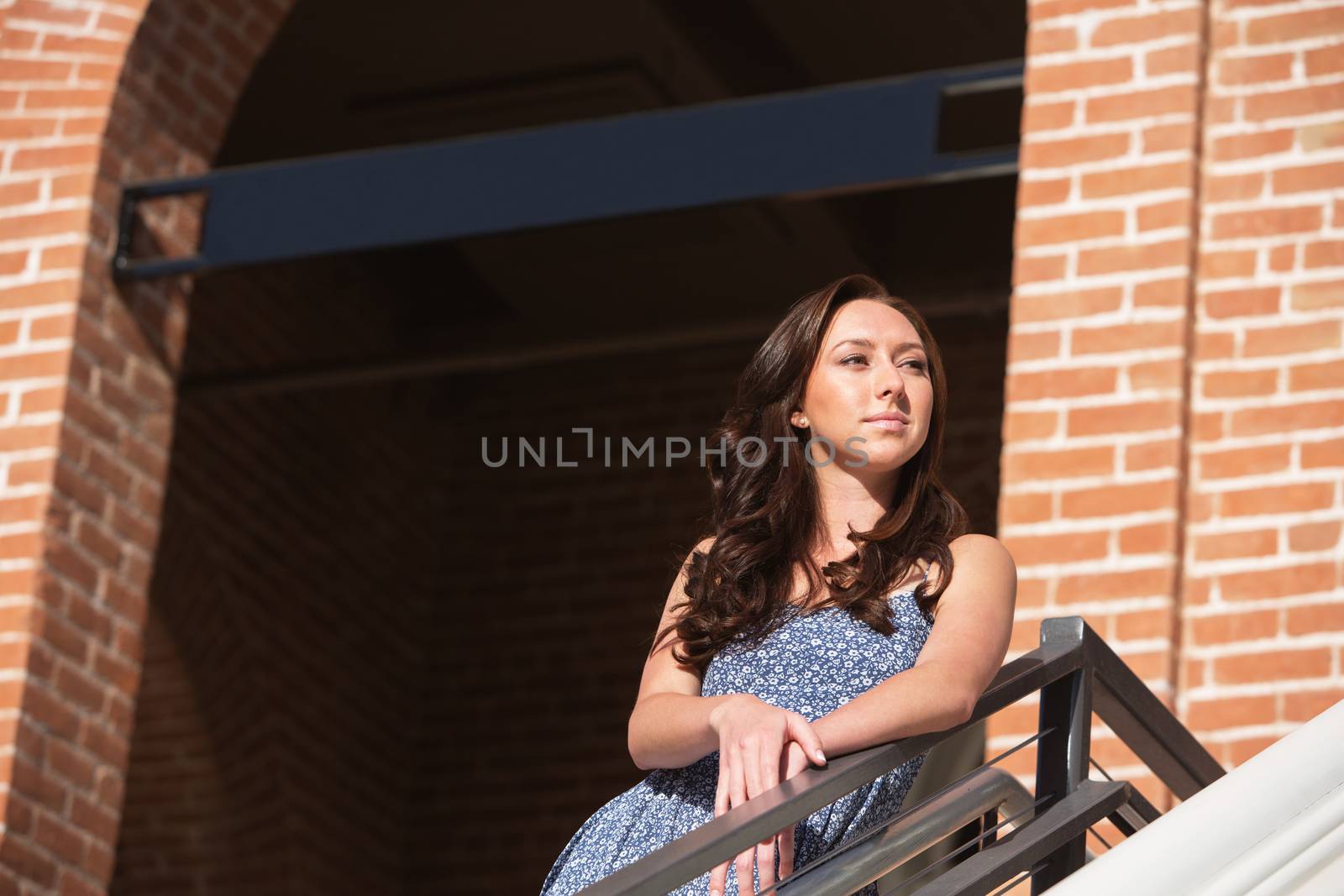 Confident single young woman standing beneath sign