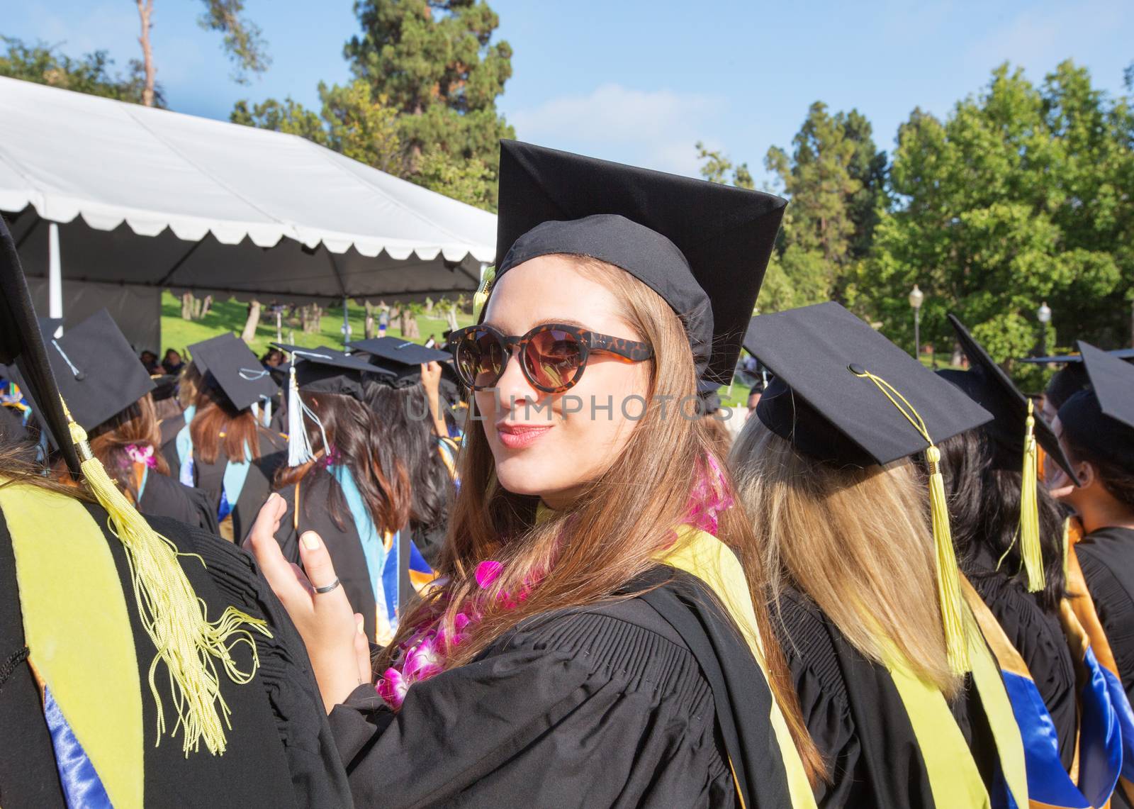 Single student applauding at college graduation ceremony