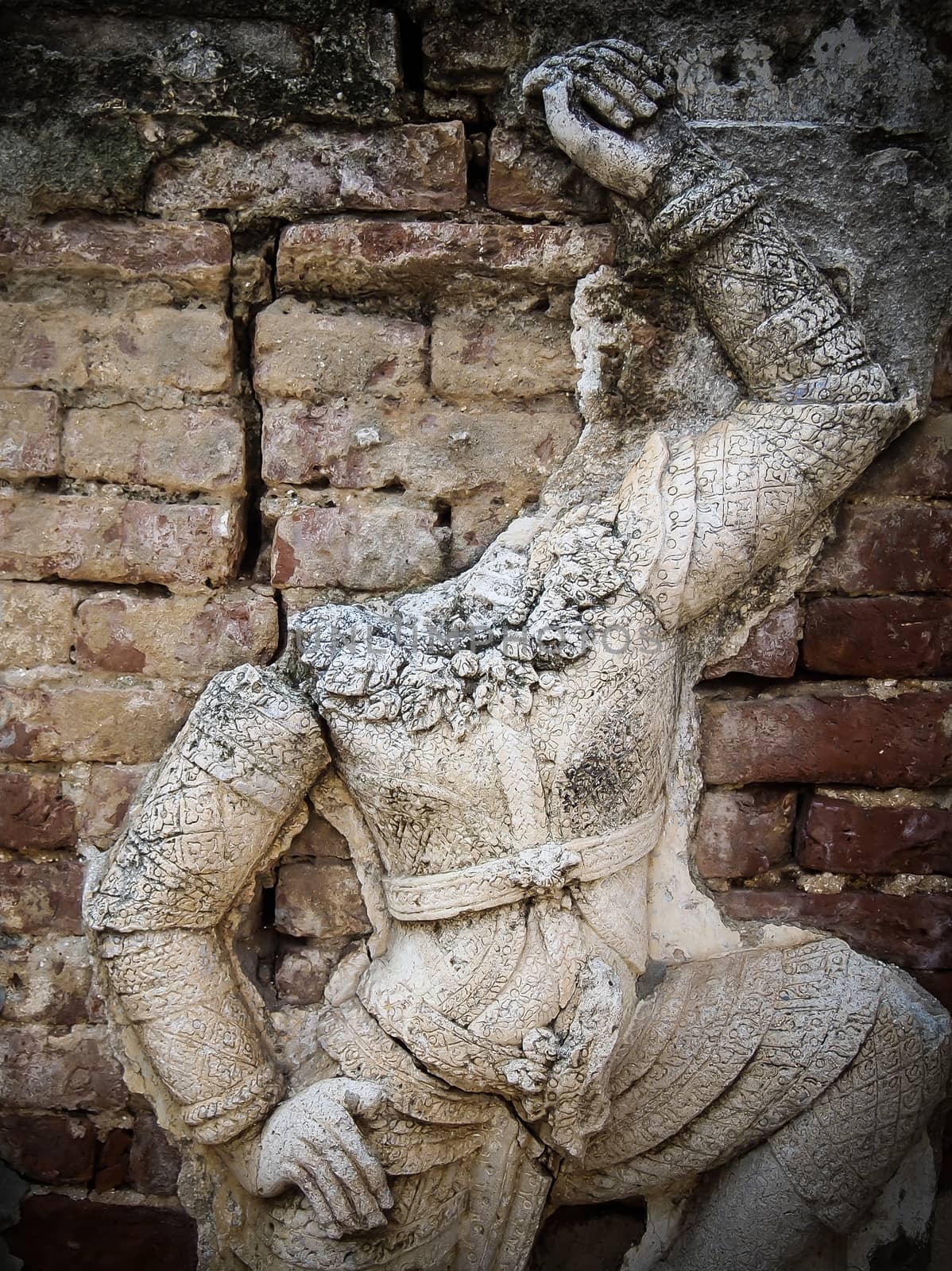 No head Thai giant stucco on old brick wall