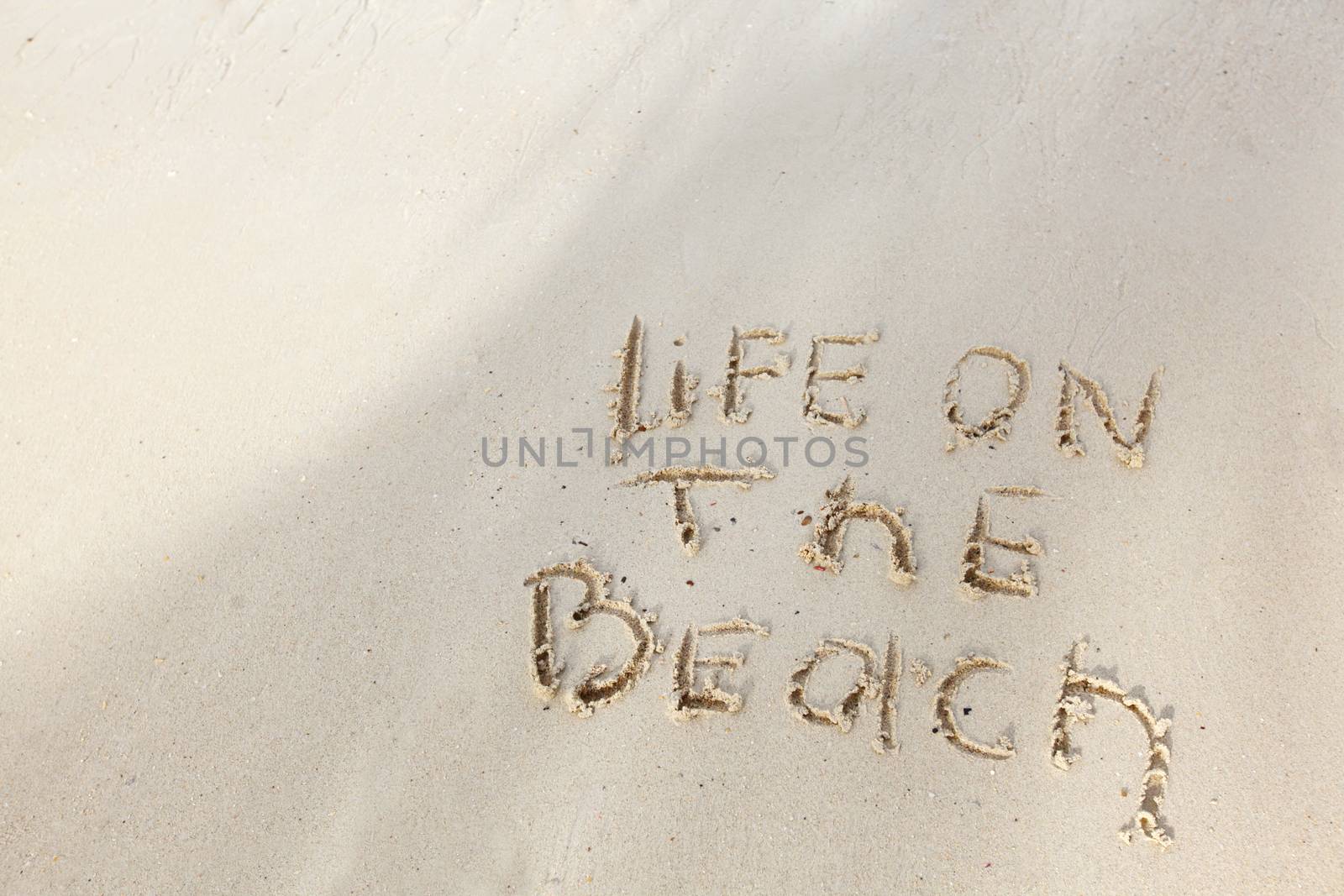 Life on the beach concept - inscription on a beach sand with coming wave