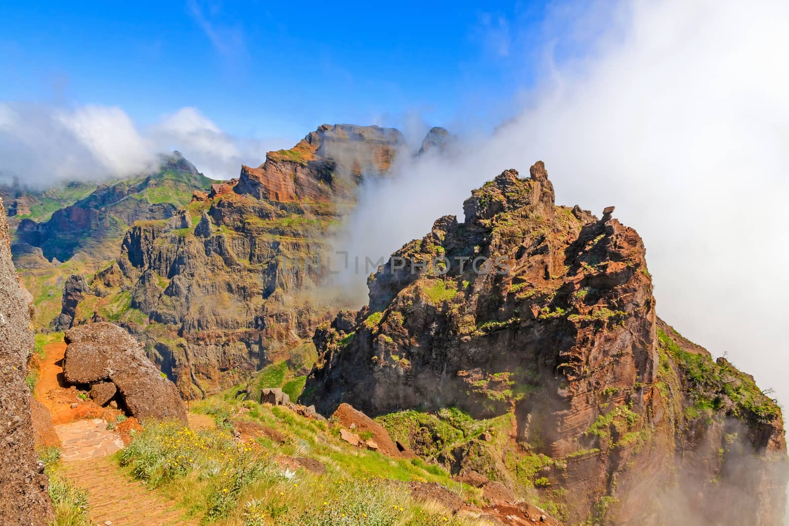 Colorful volcanic mountain landscape with clouds - hiking path from Pico do Arieiro to Pico Ruivo, Madeira, Portugal