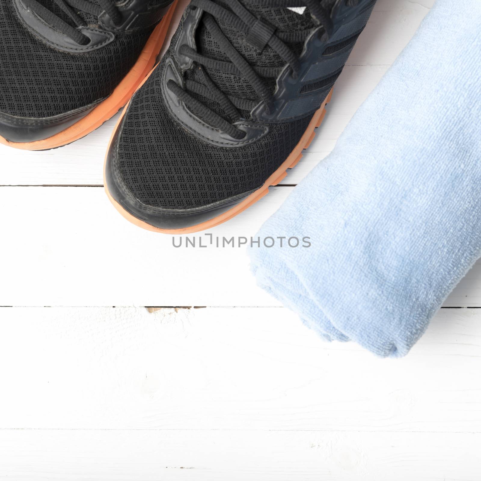 running shoes and towel on white wood table