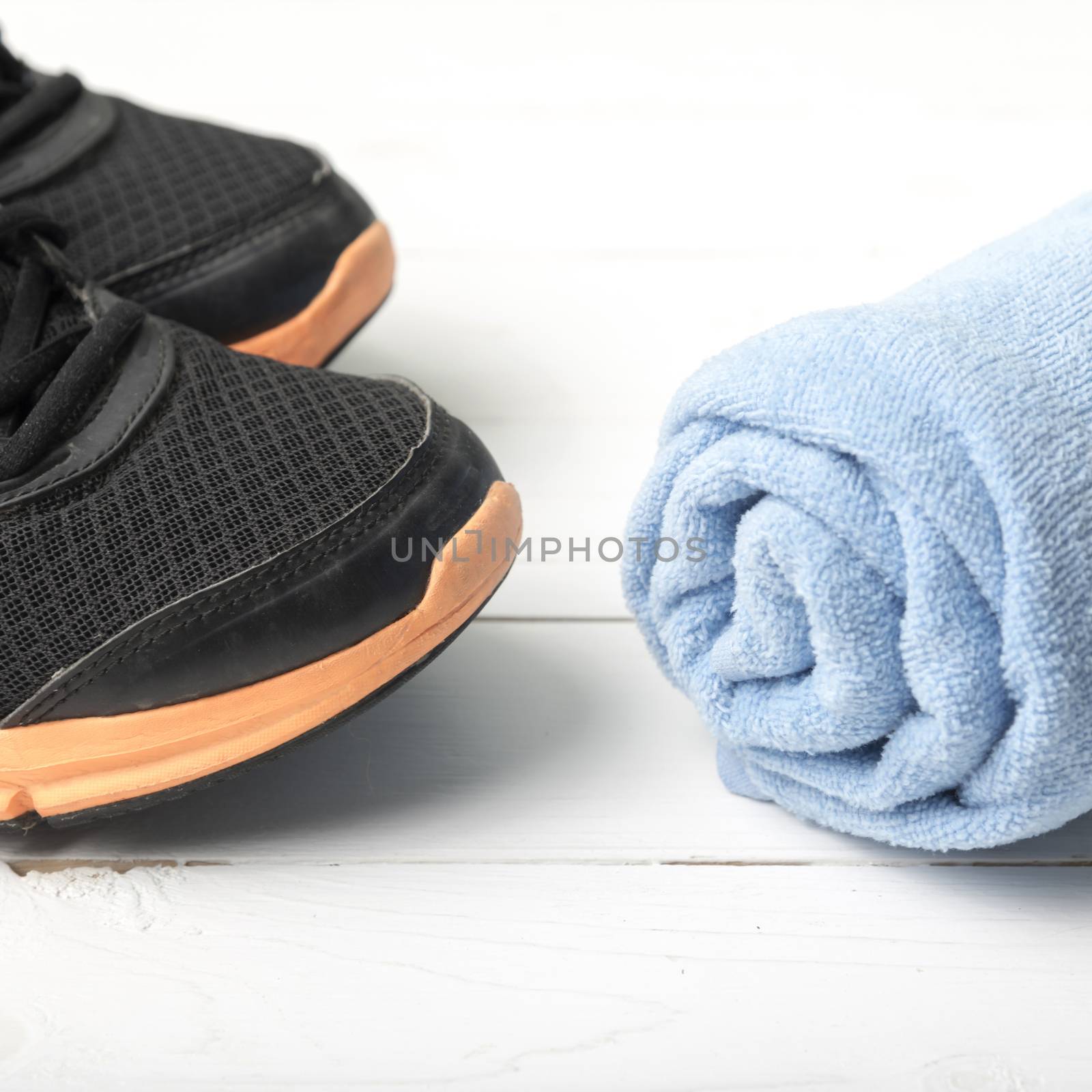 running shoes and towel on white wood table