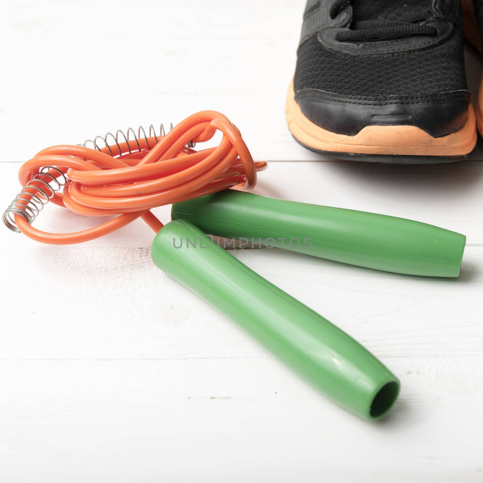 running shoes and jumping rope on white table