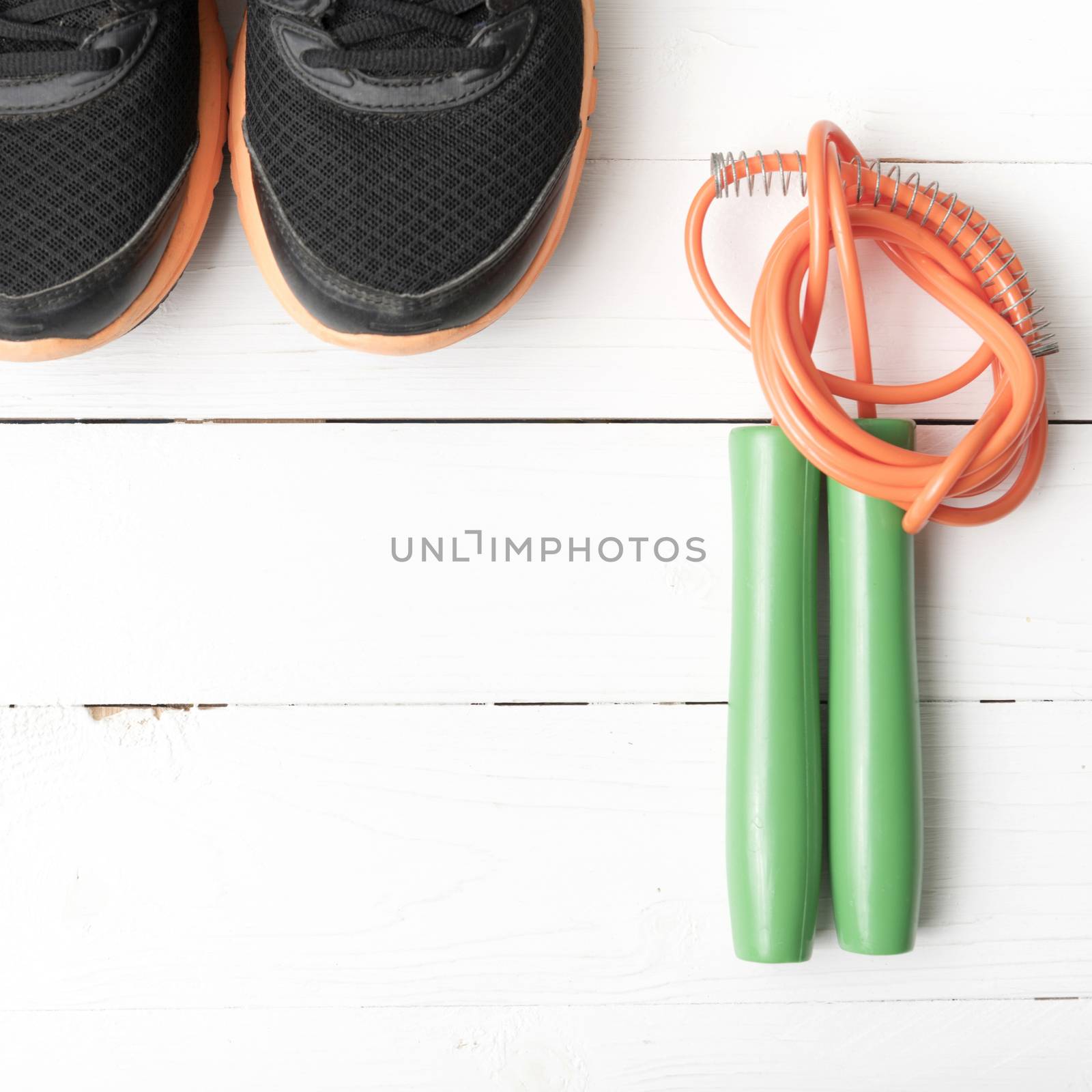 running shoes and jumping rope on white table