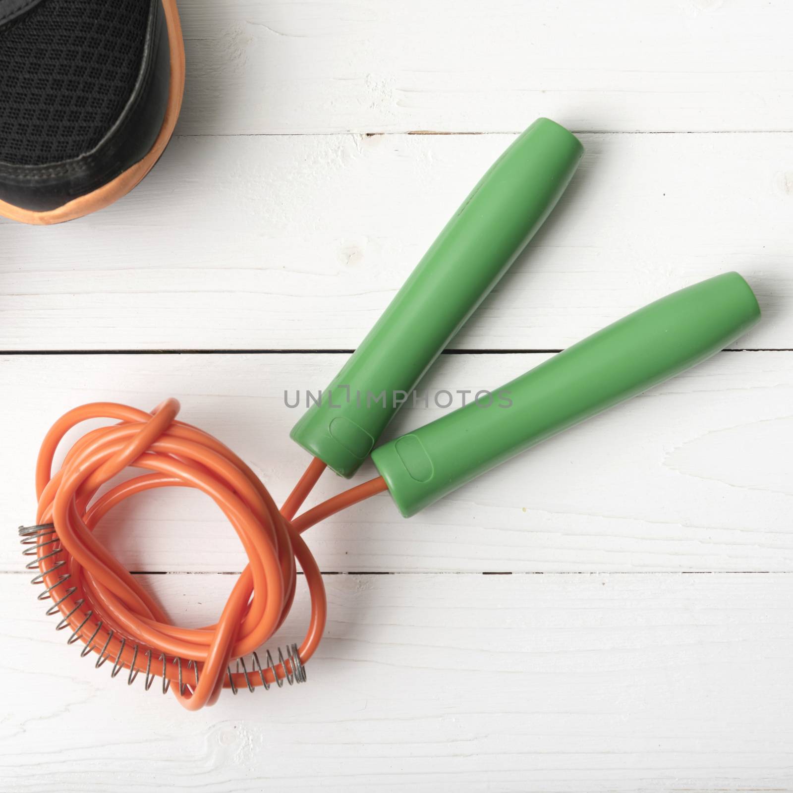 running shoes and jumping rope on white table