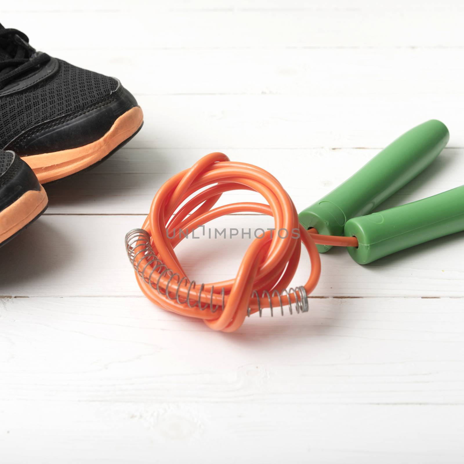 running shoes and jumping rope on white table