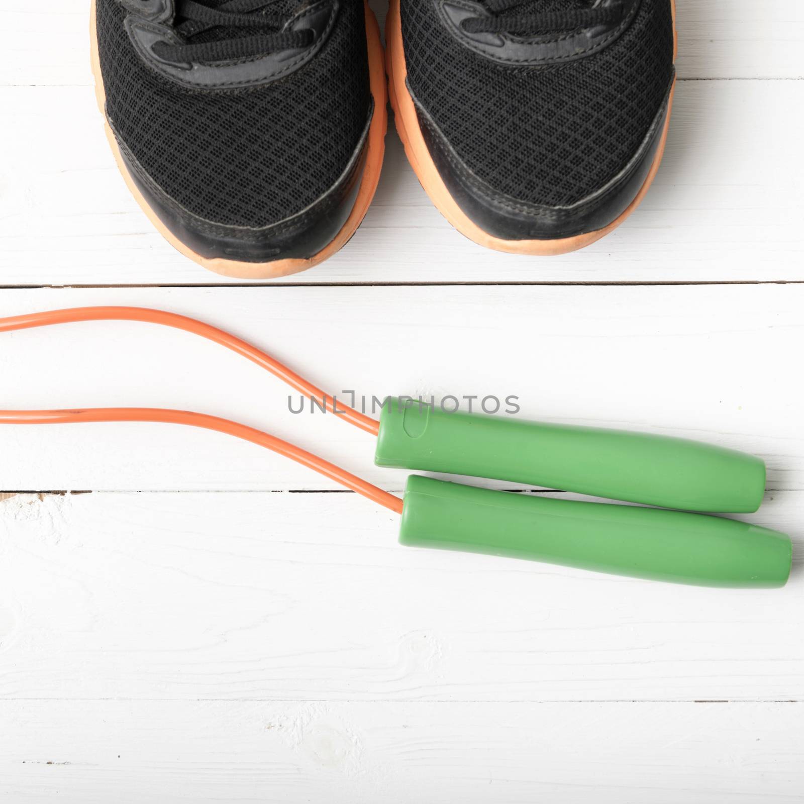 running shoes and jumping rope on white table