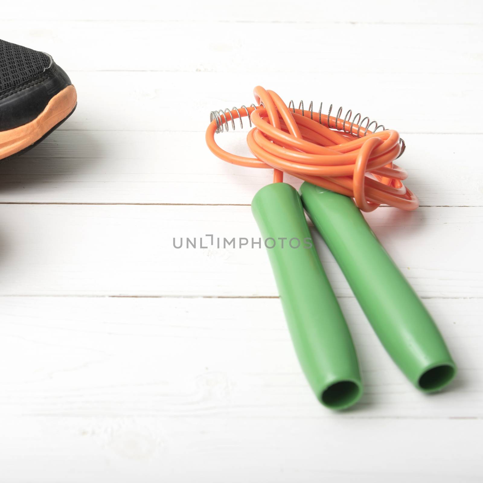 running shoes and jumping rope on white table