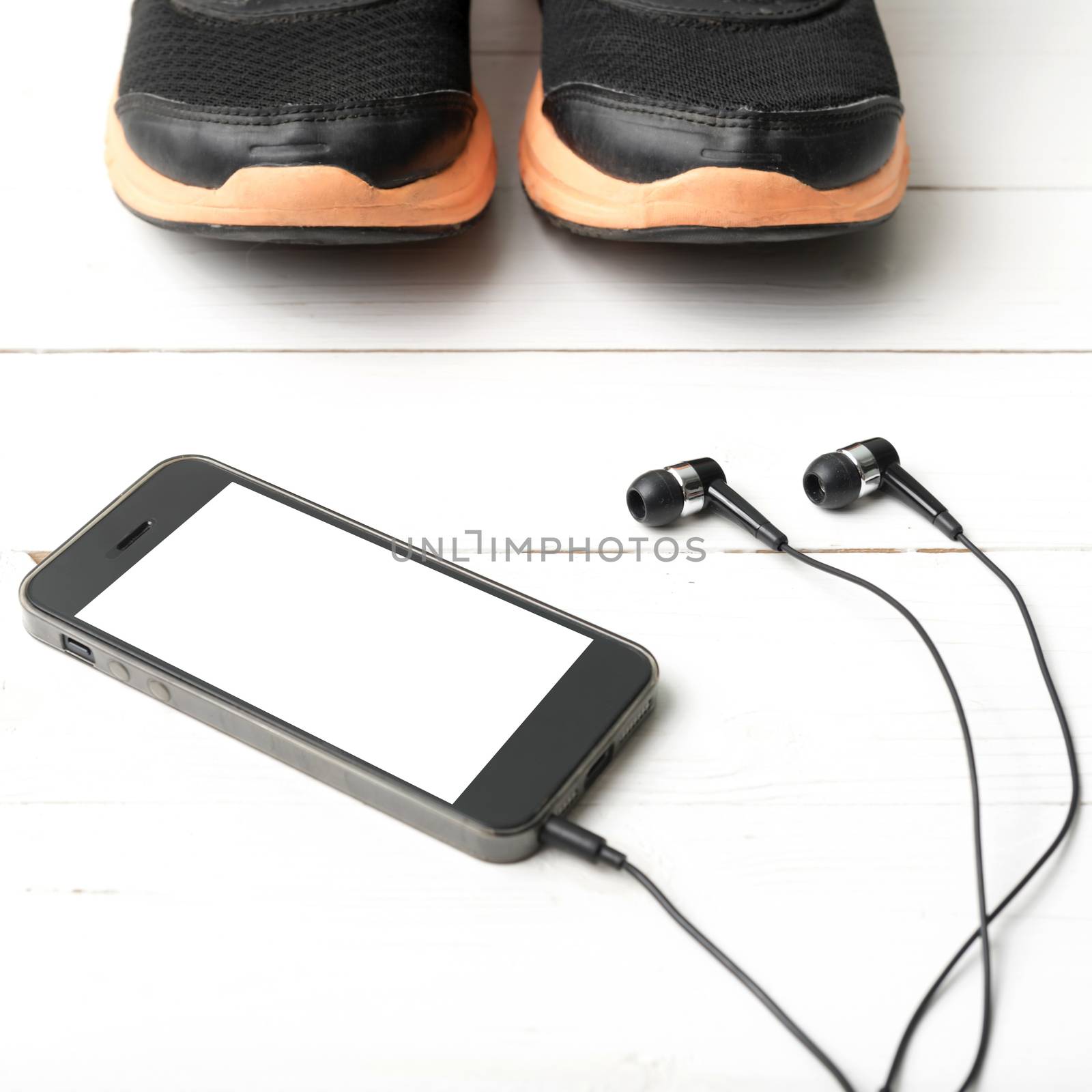 running shoes and phone on white wood table