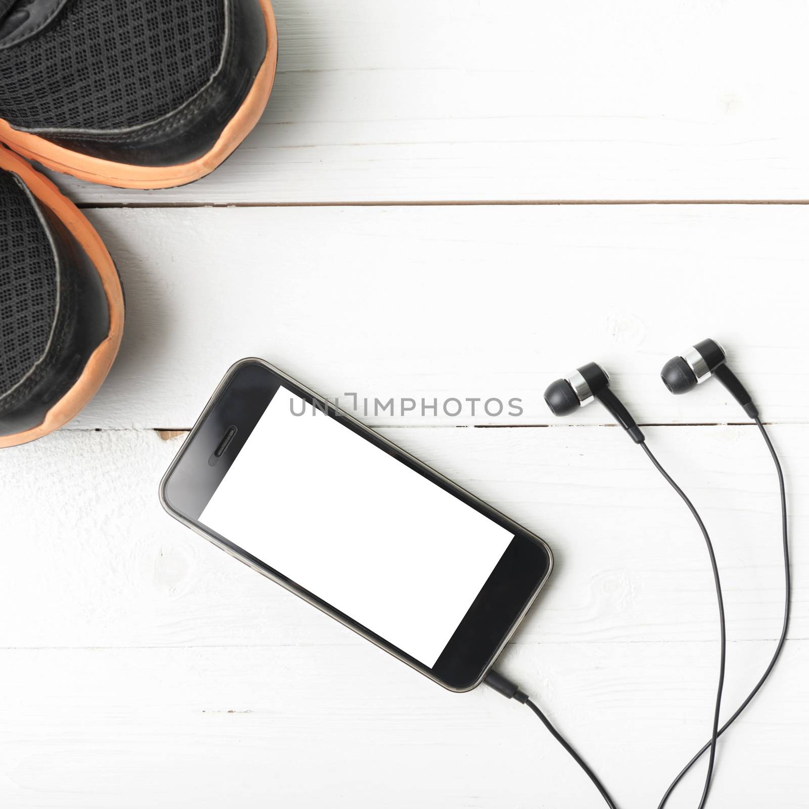 running shoes and phone on white wood table