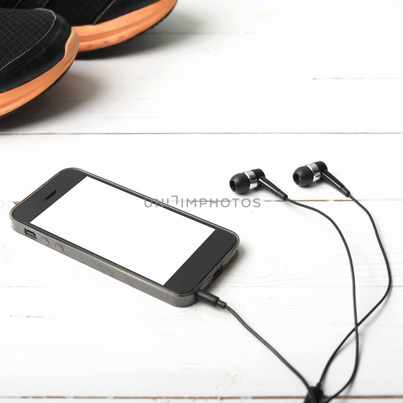 running shoes and phone on white wood table