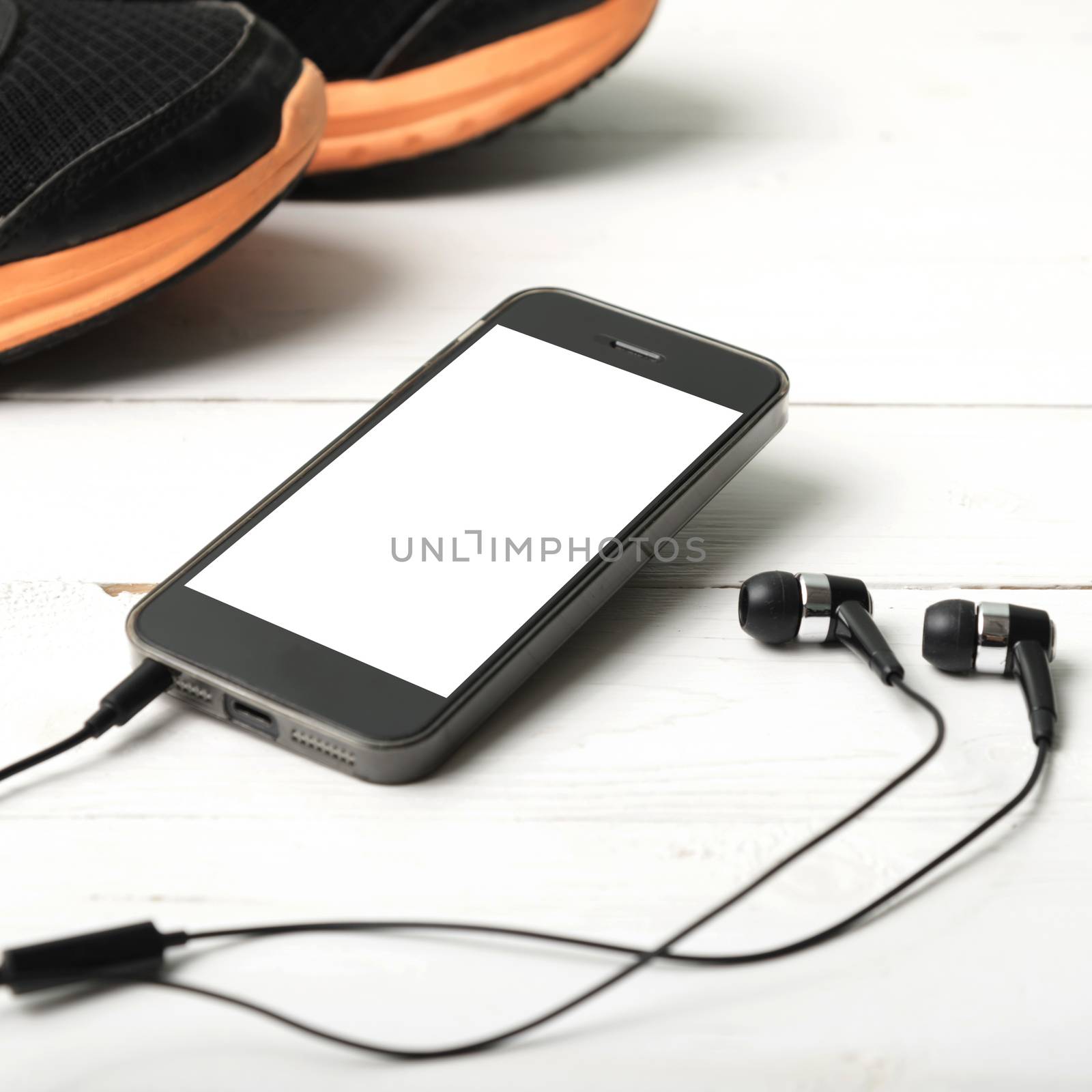 running shoes and phone on white wood table