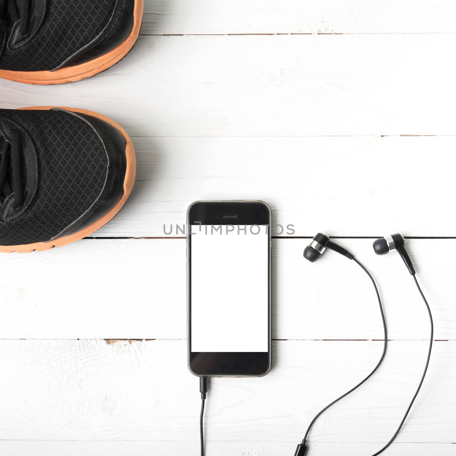running shoes and phone on white wood table