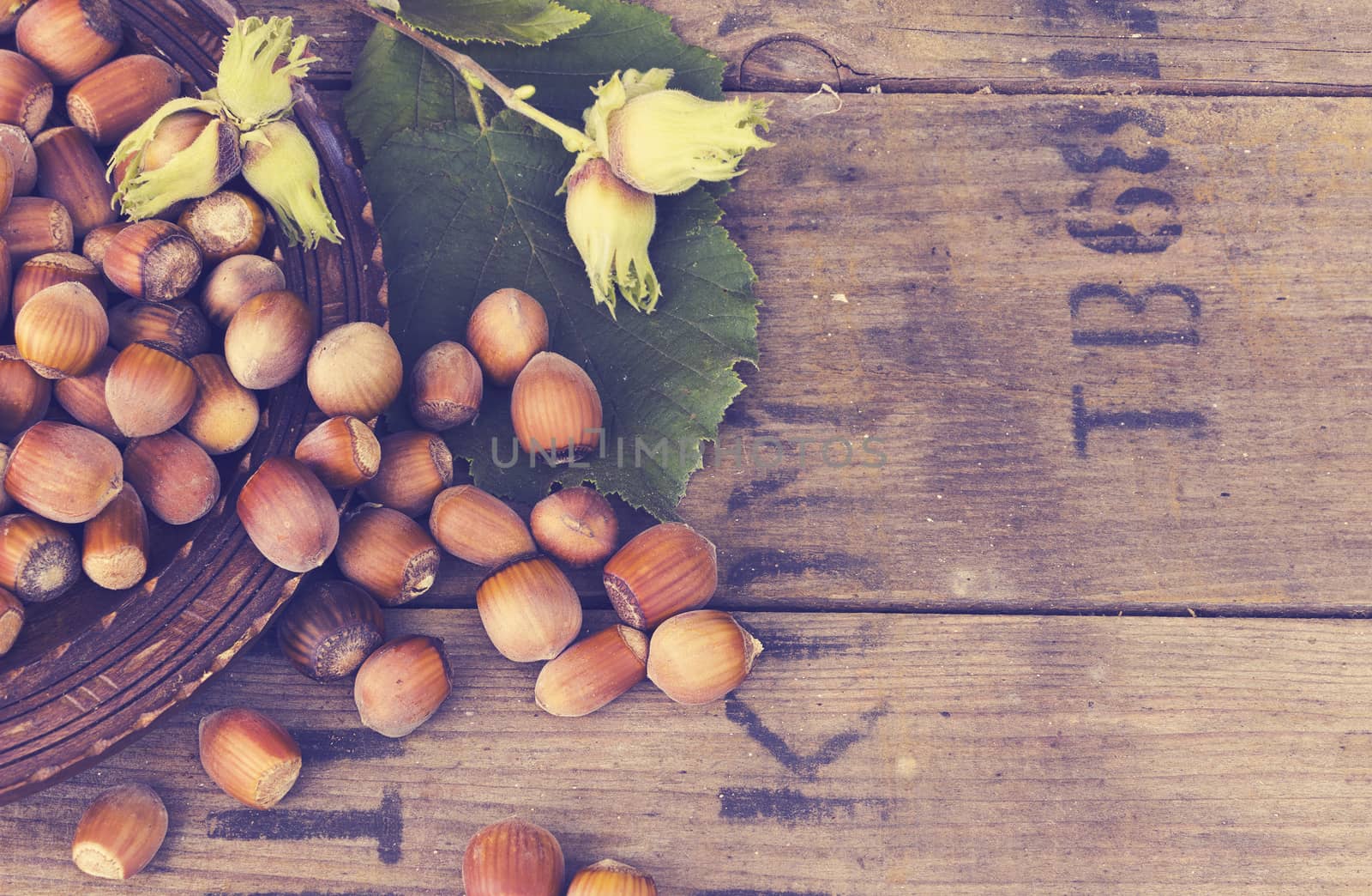 Hazelnut in  bowl on wooden background with filter effect retro vintage style