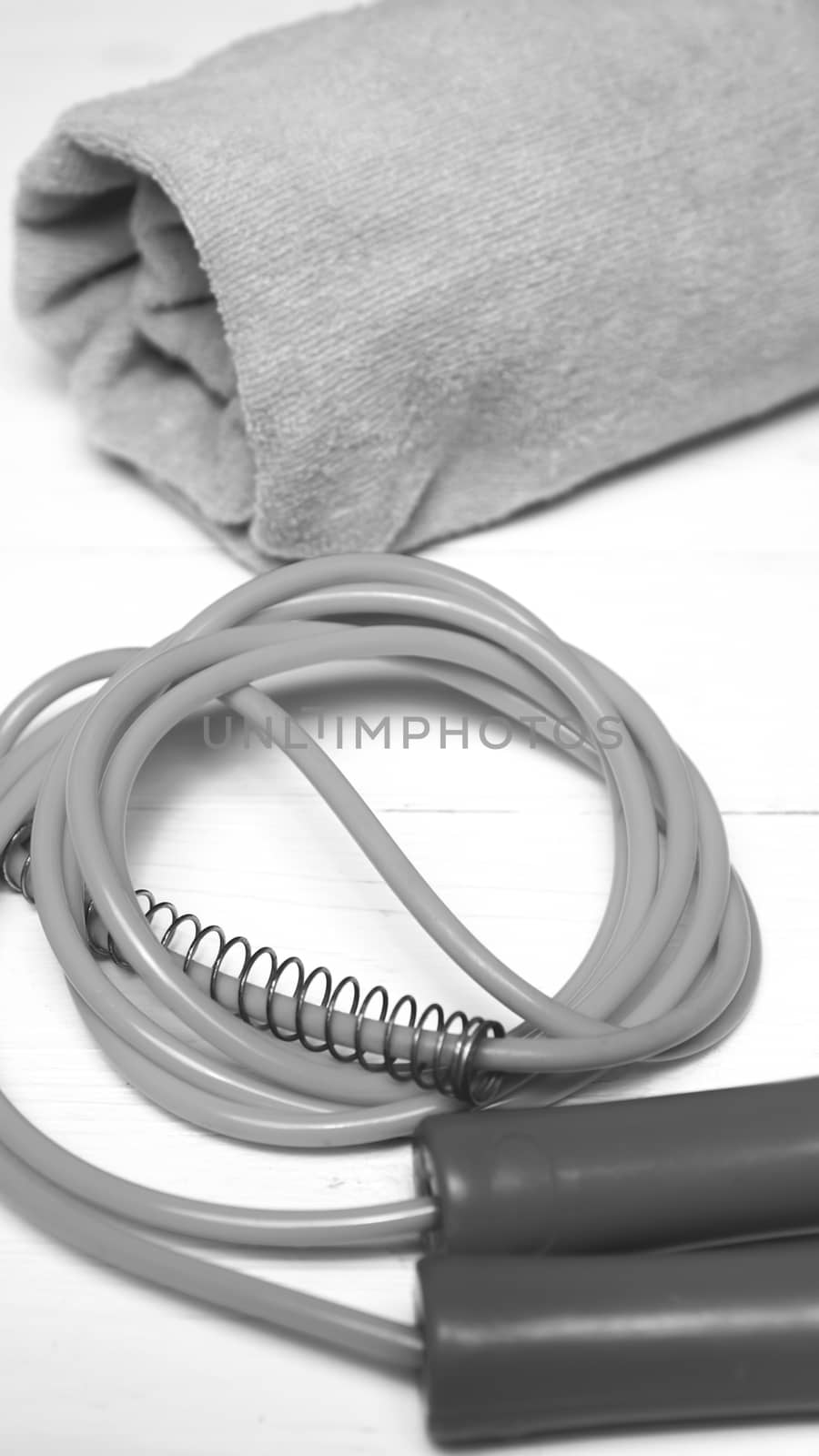 fitness equipment:towel,jumping rope on white wood table black and white color style