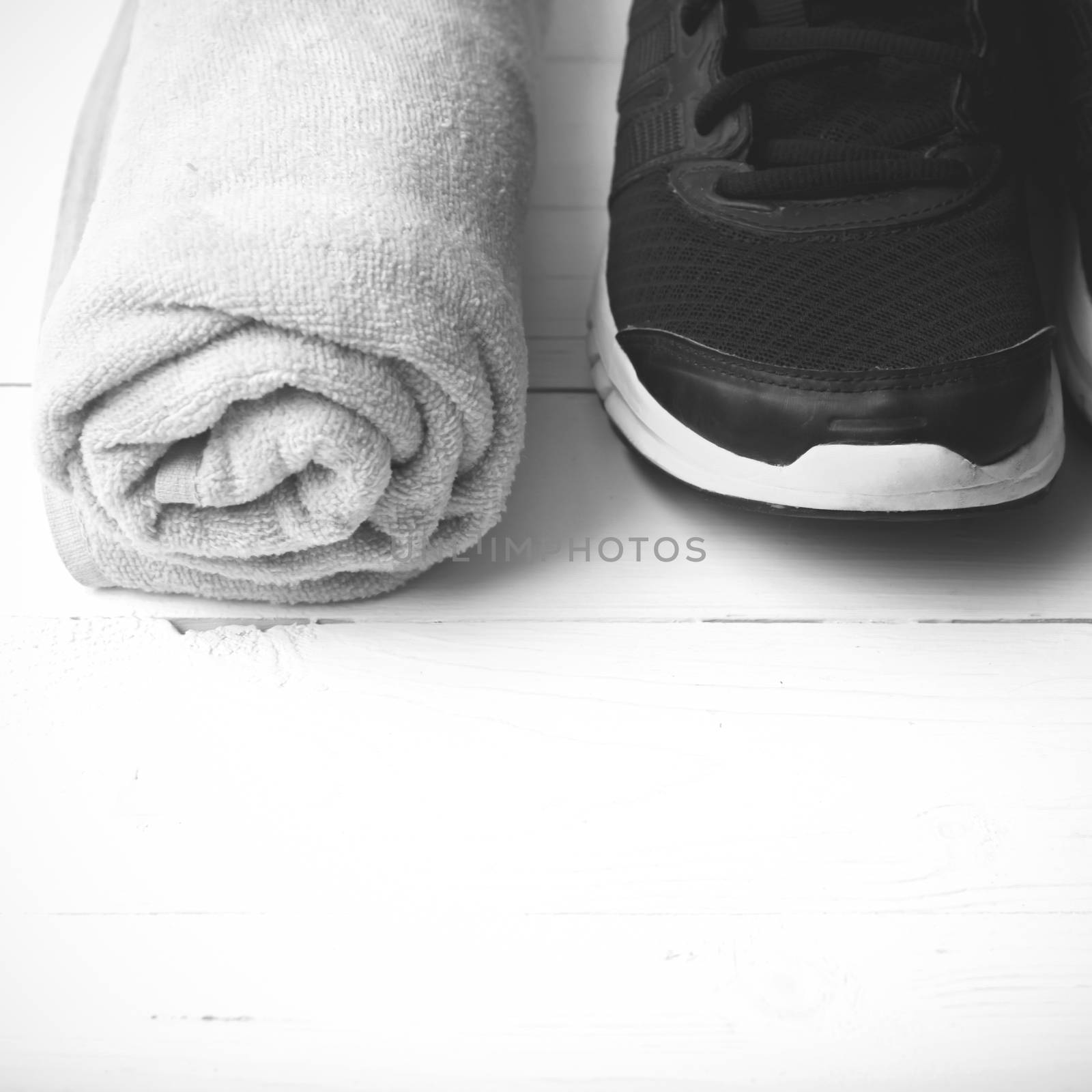 running shoes and towel on white wood table black and white tone color style