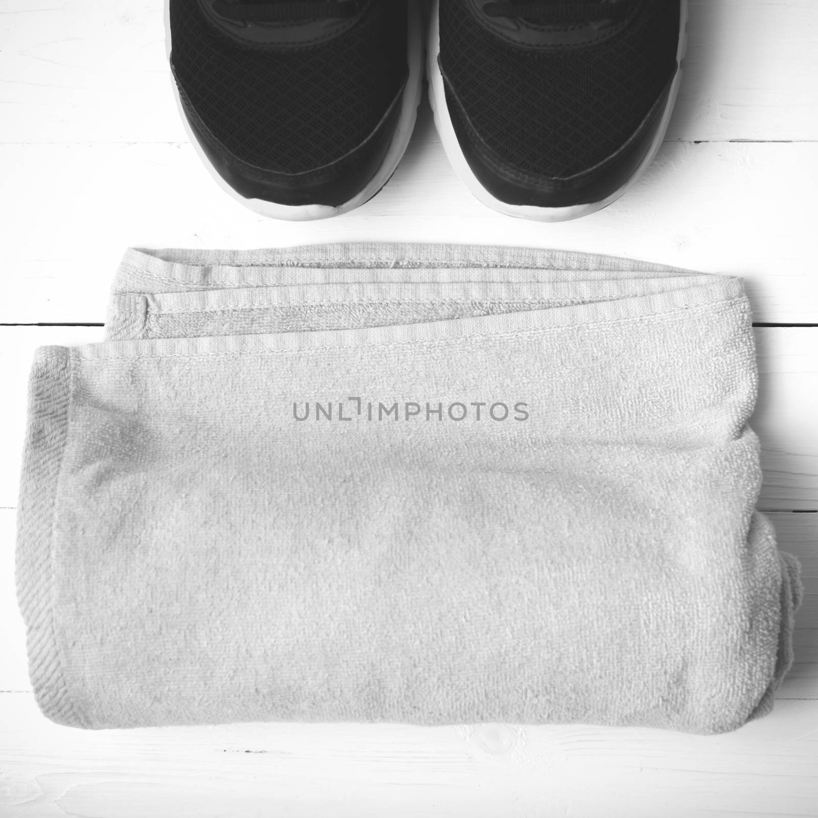 running shoes and towel on white wood table black and white tone color style