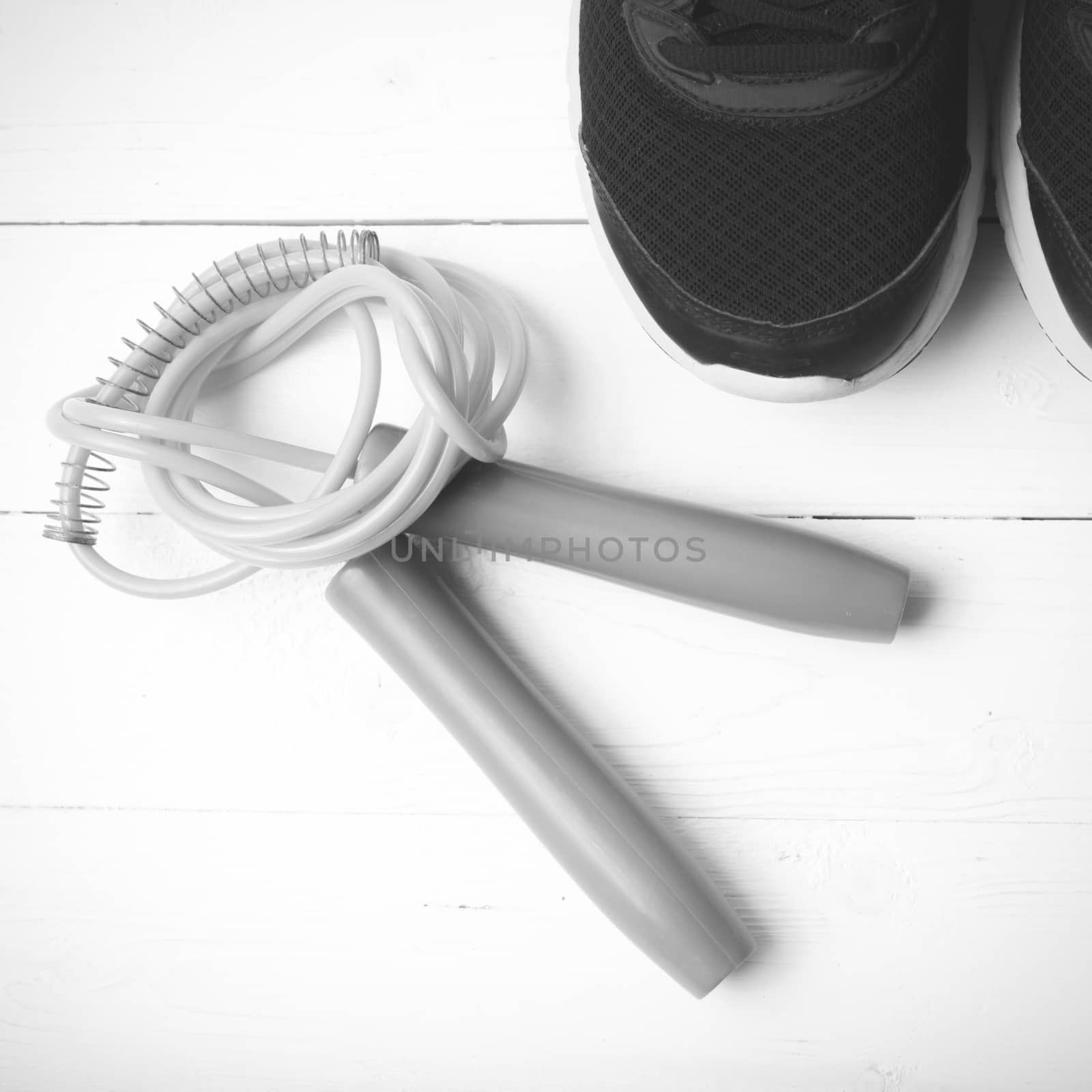 running shoes and jumping rope on white table black and white tone color style