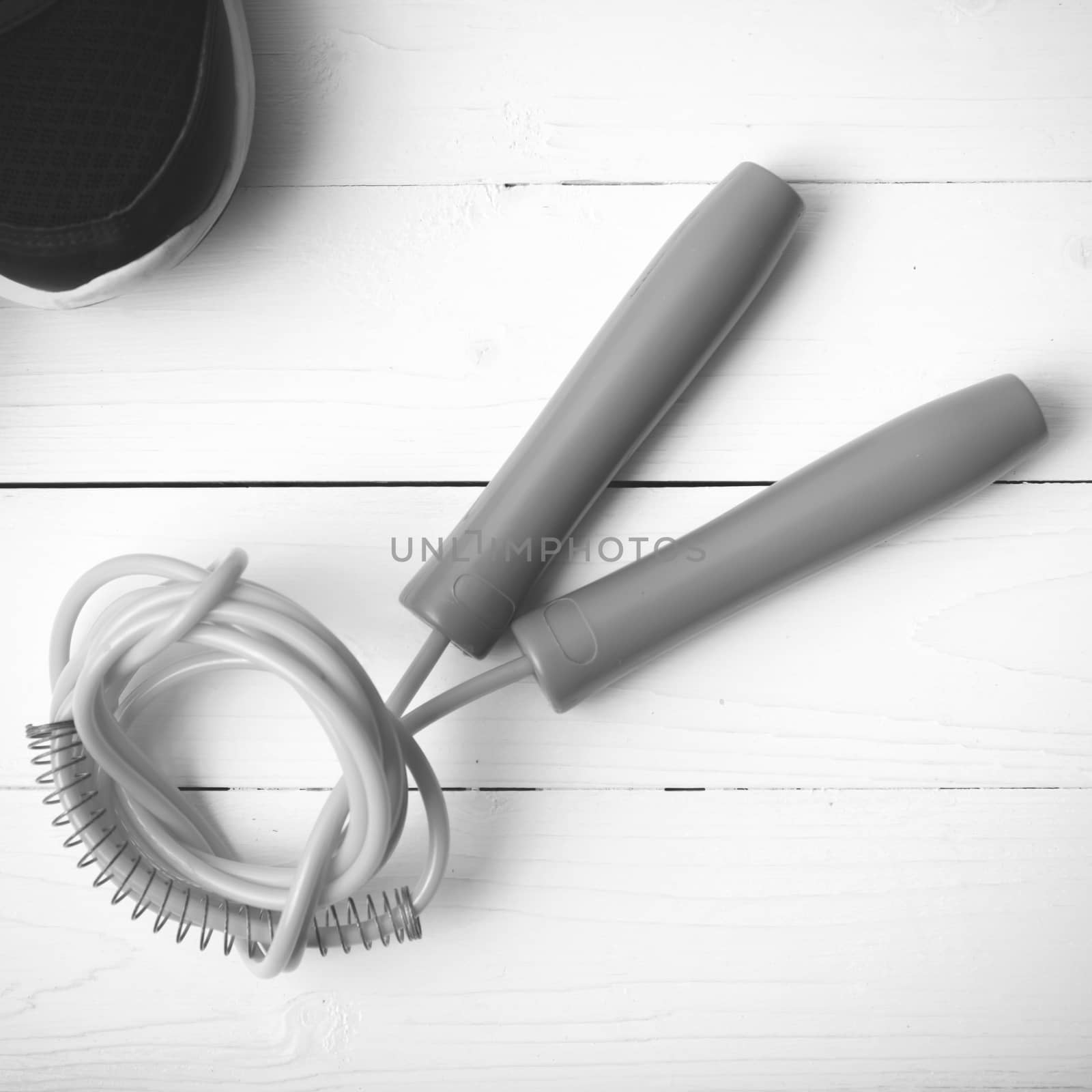 running shoes and jumping rope on white table black and white tone color style