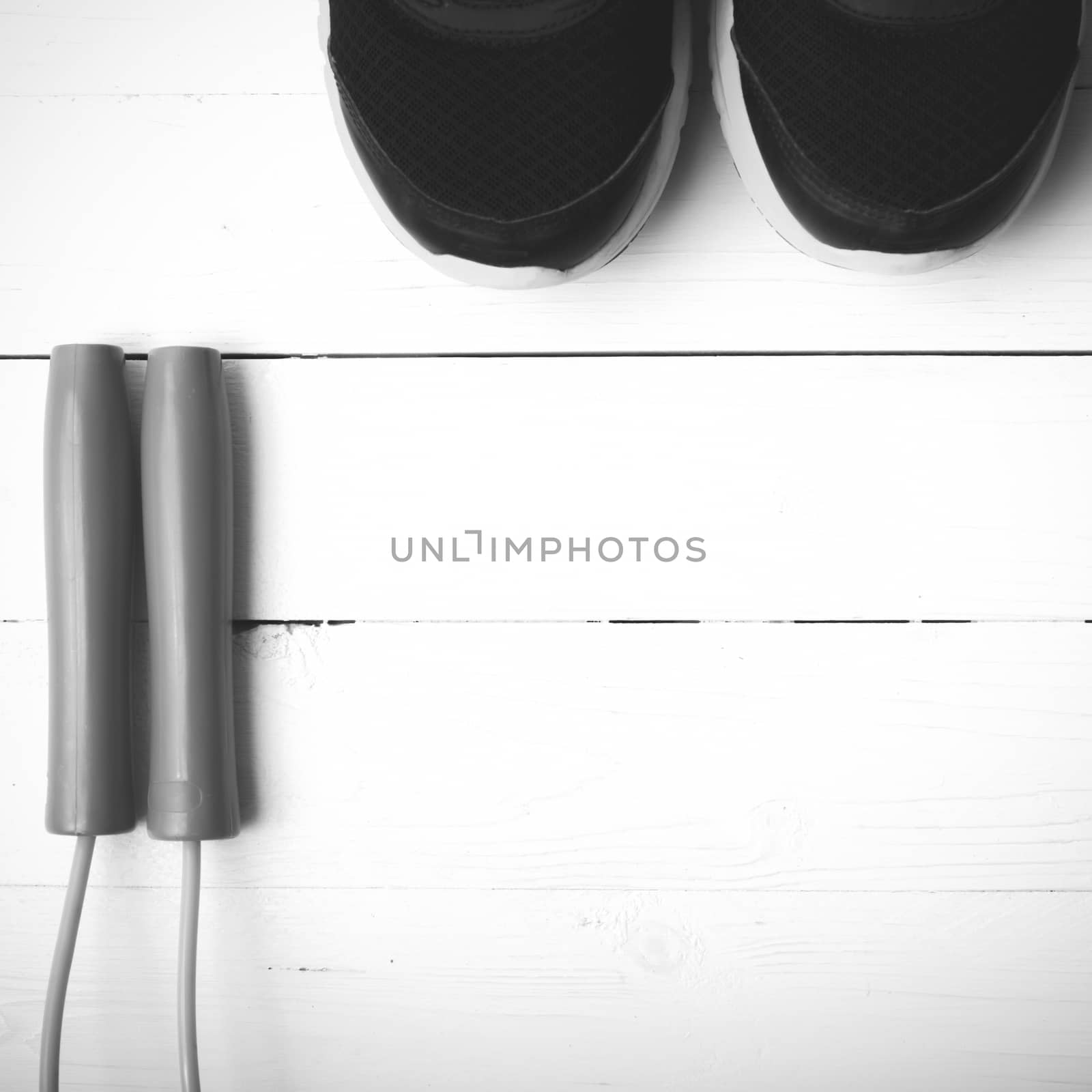 running shoes and jumping rope on white table black and white tone color style