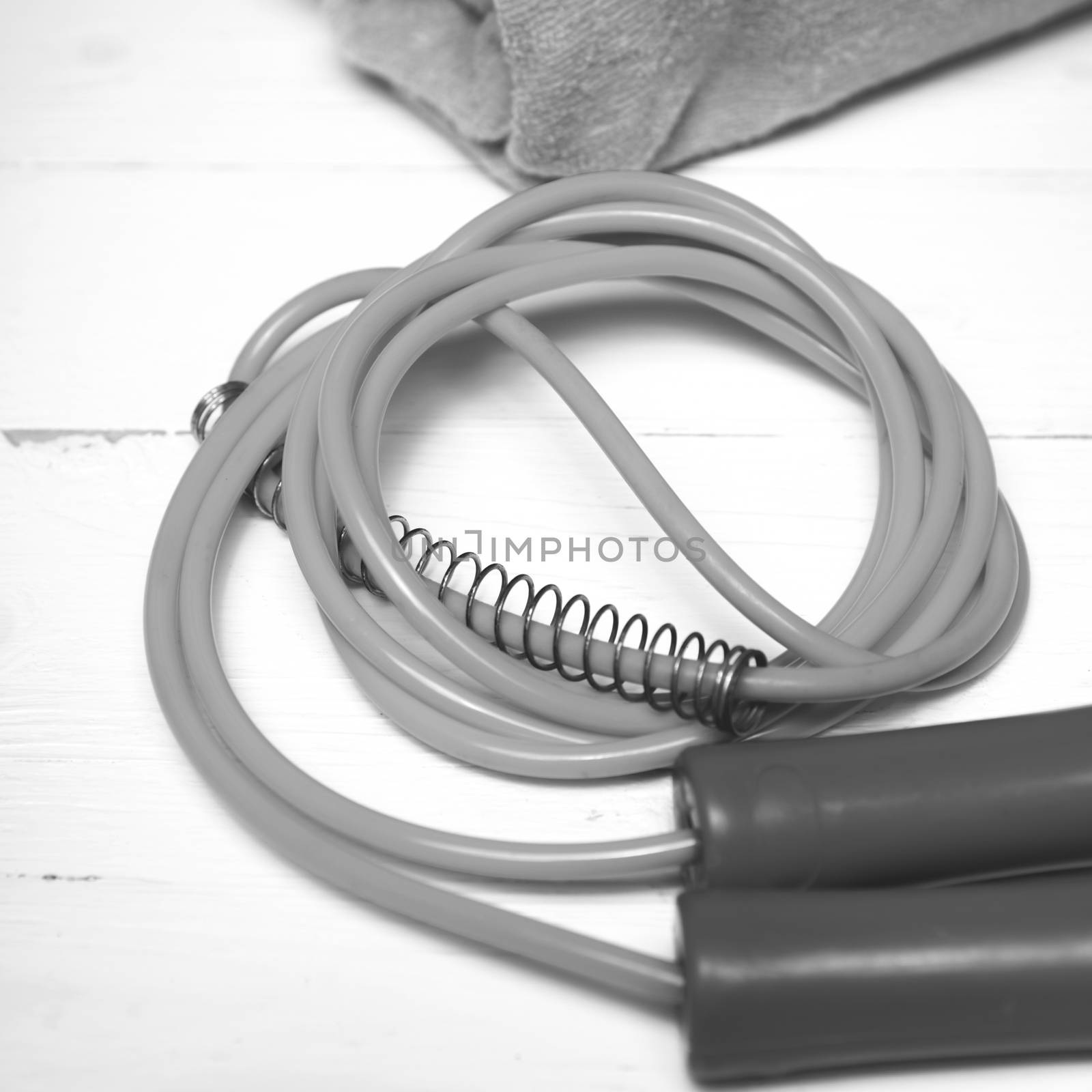 fitness equipment:towel,jumping rope on white wood table black and white color style