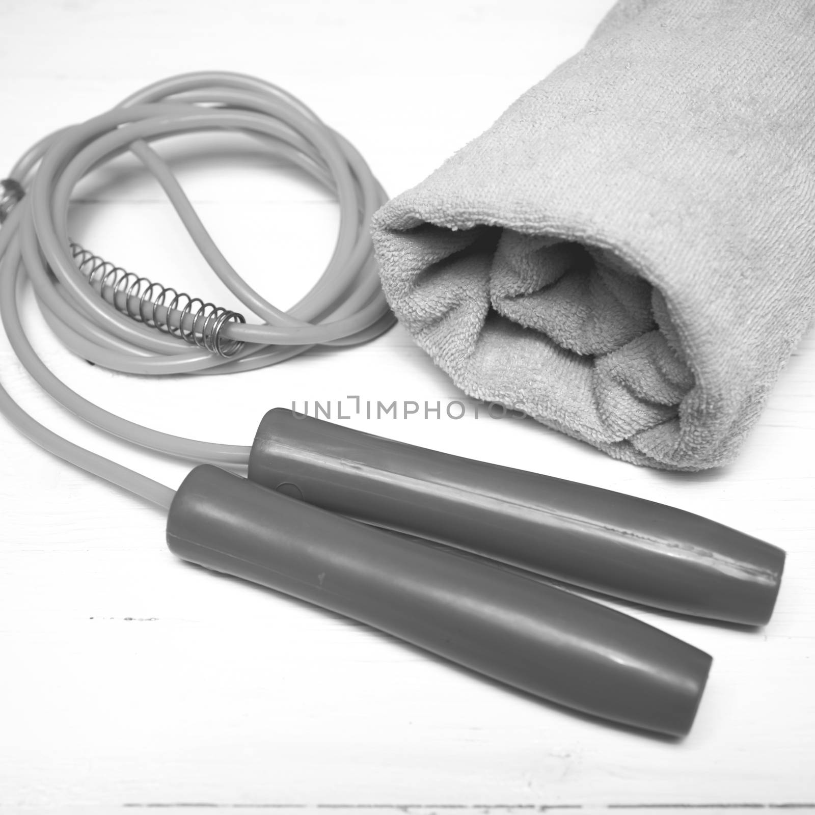 fitness equipment:towel,jumping rope on white wood table black and white color style