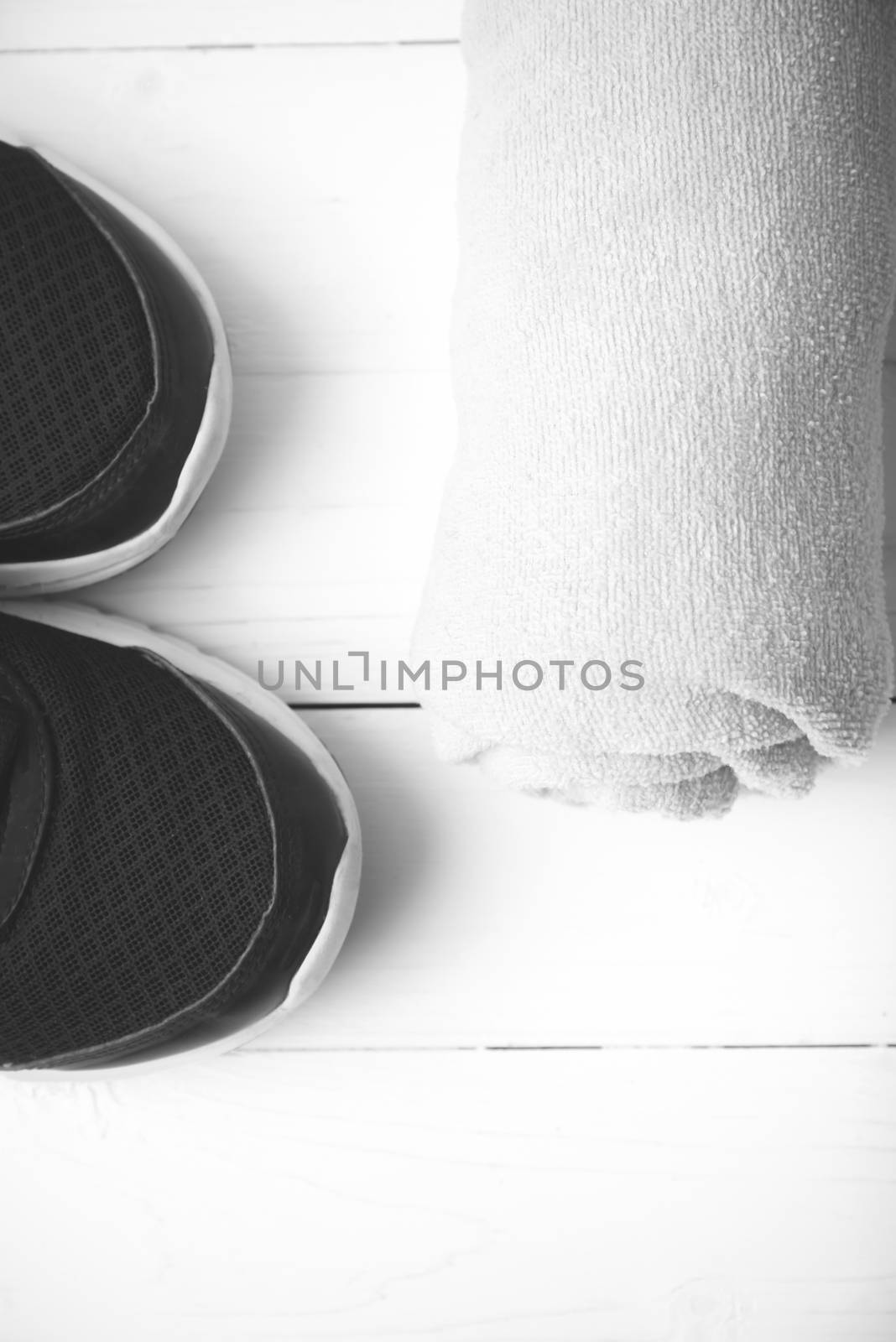 running shoes and towel on white wood table black and white tone color style