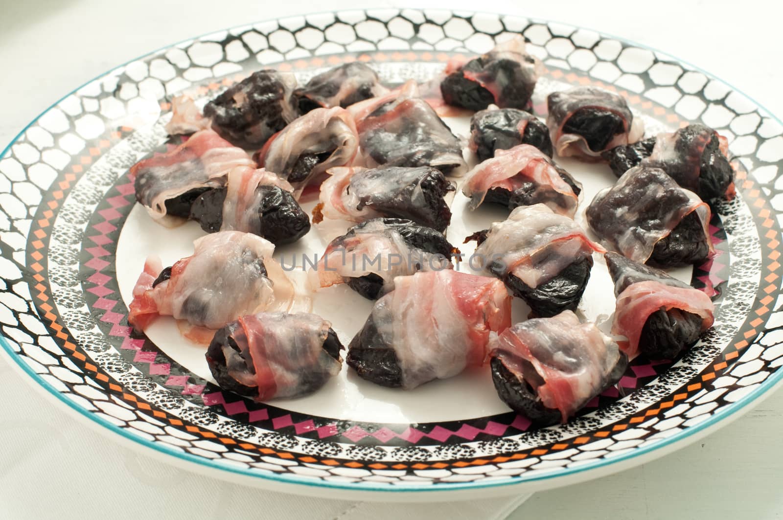 Prunes wrapped in bacon and baked, italy