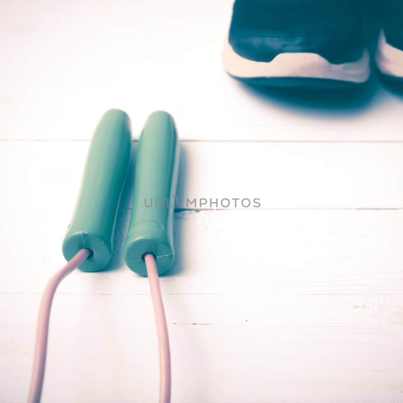 running shoes and jumping rope on white table vintage style