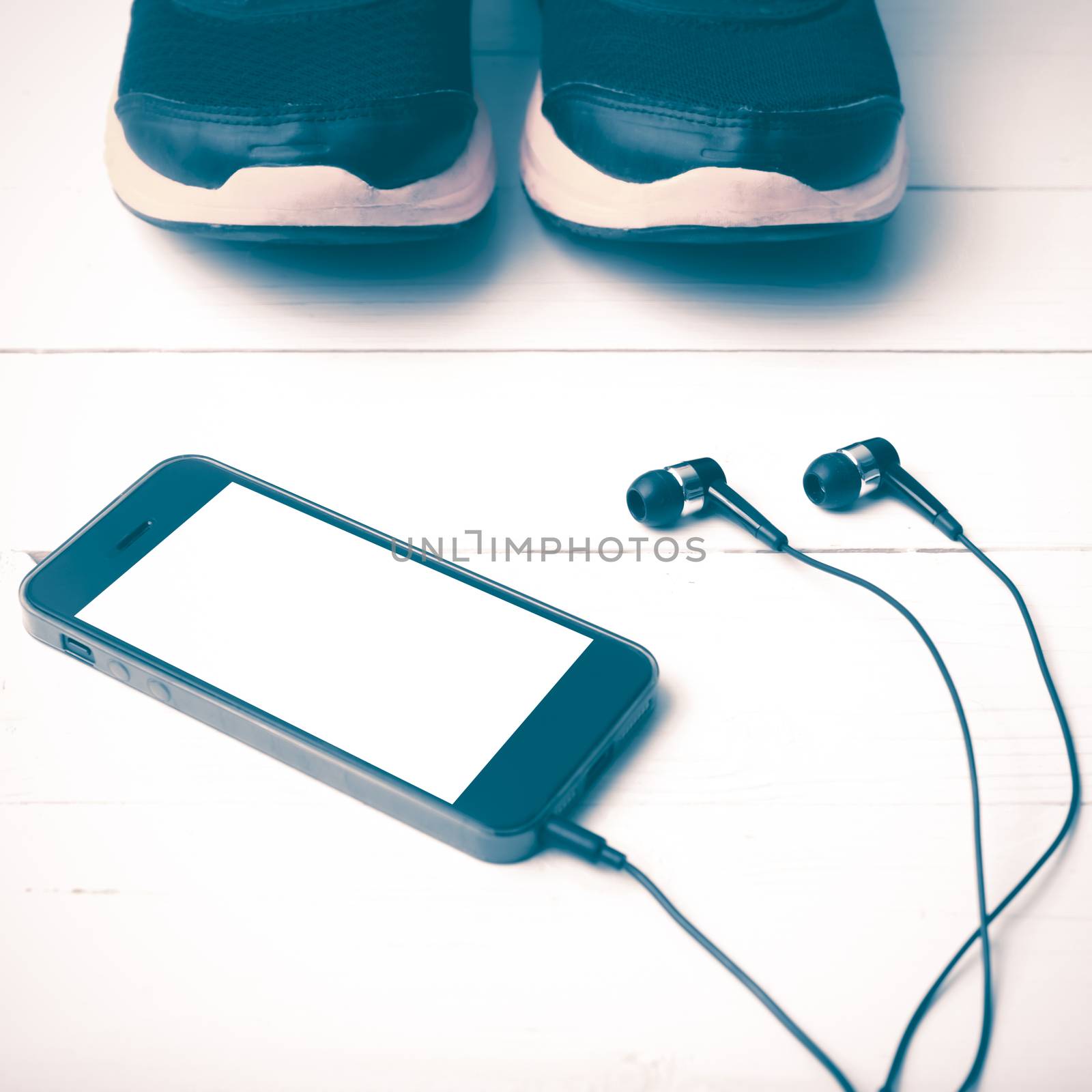 running shoes and phone on white wood table vintage style