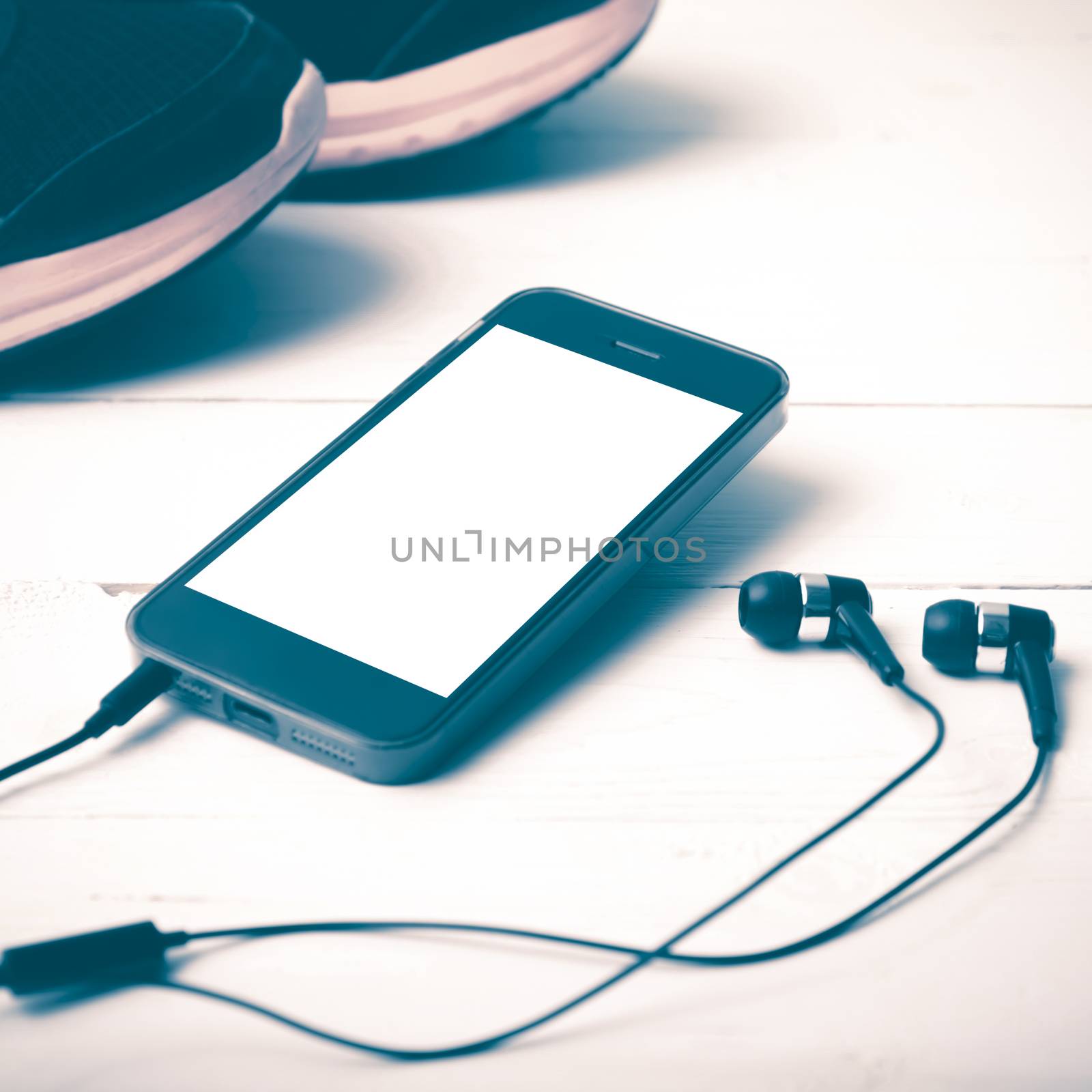 running shoes and phone on white wood table vintage style