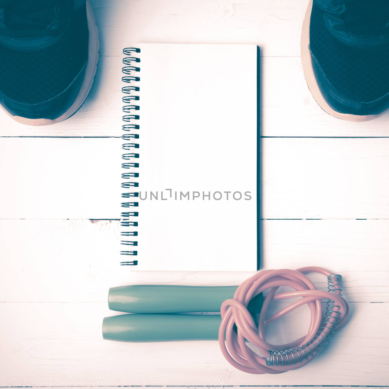 fitness equipment : running shoes,jumping rope and notepad on white wood table vintage style