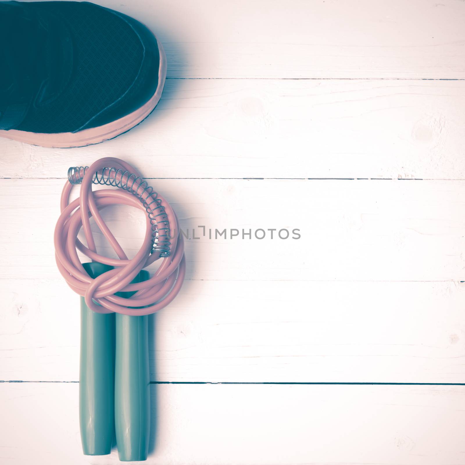 fitness equipment : running shoes,jumping rope on white wood table vintage style