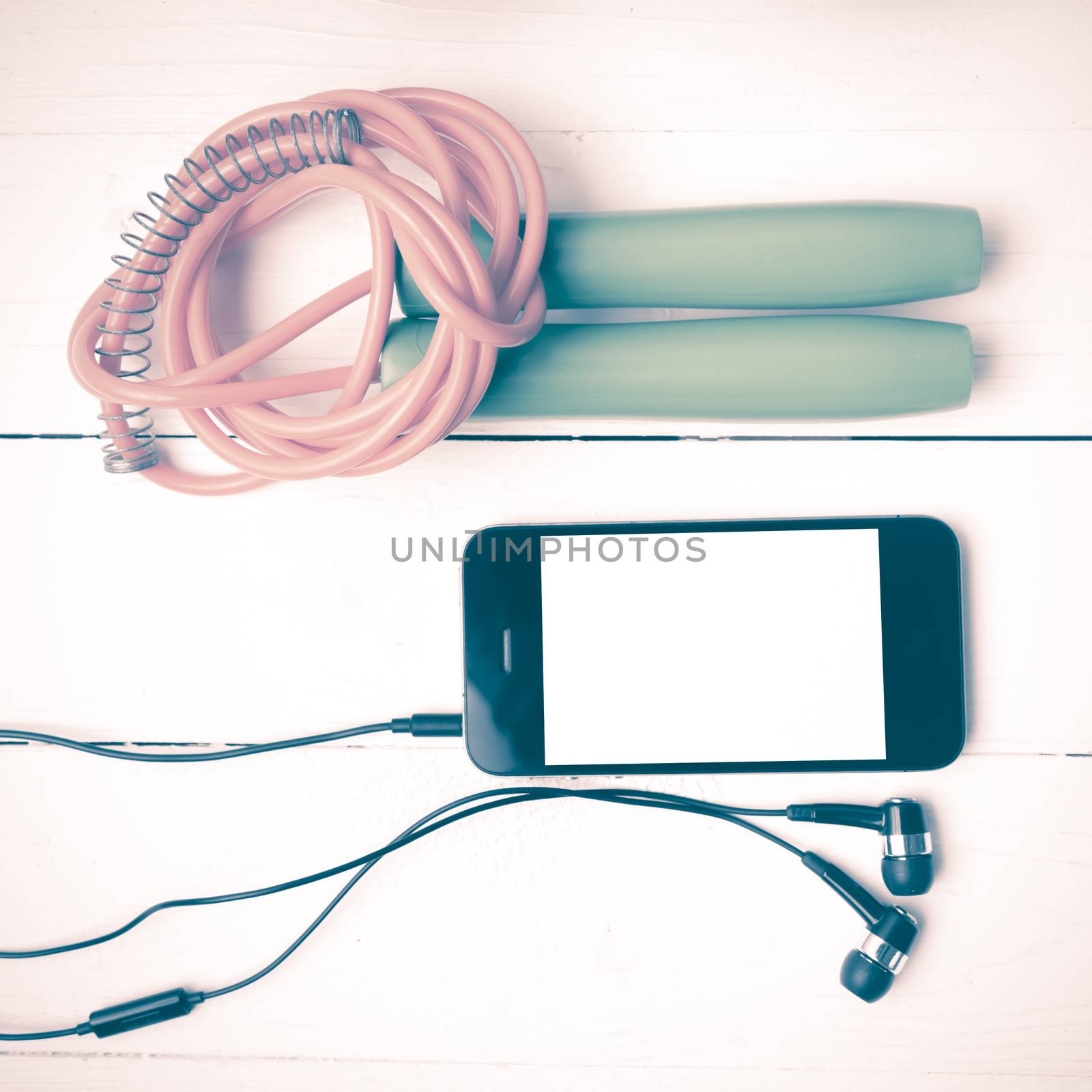 fitness equipment : jumping rope and phone on white wood table vintage style