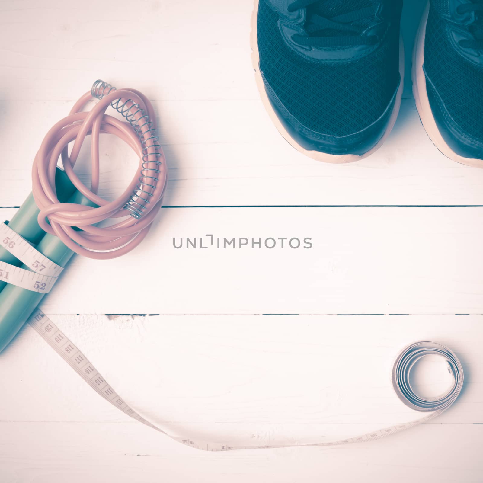 fitness equipment : running shoes,jumping rope and measuring tape  on white wood table vintage style