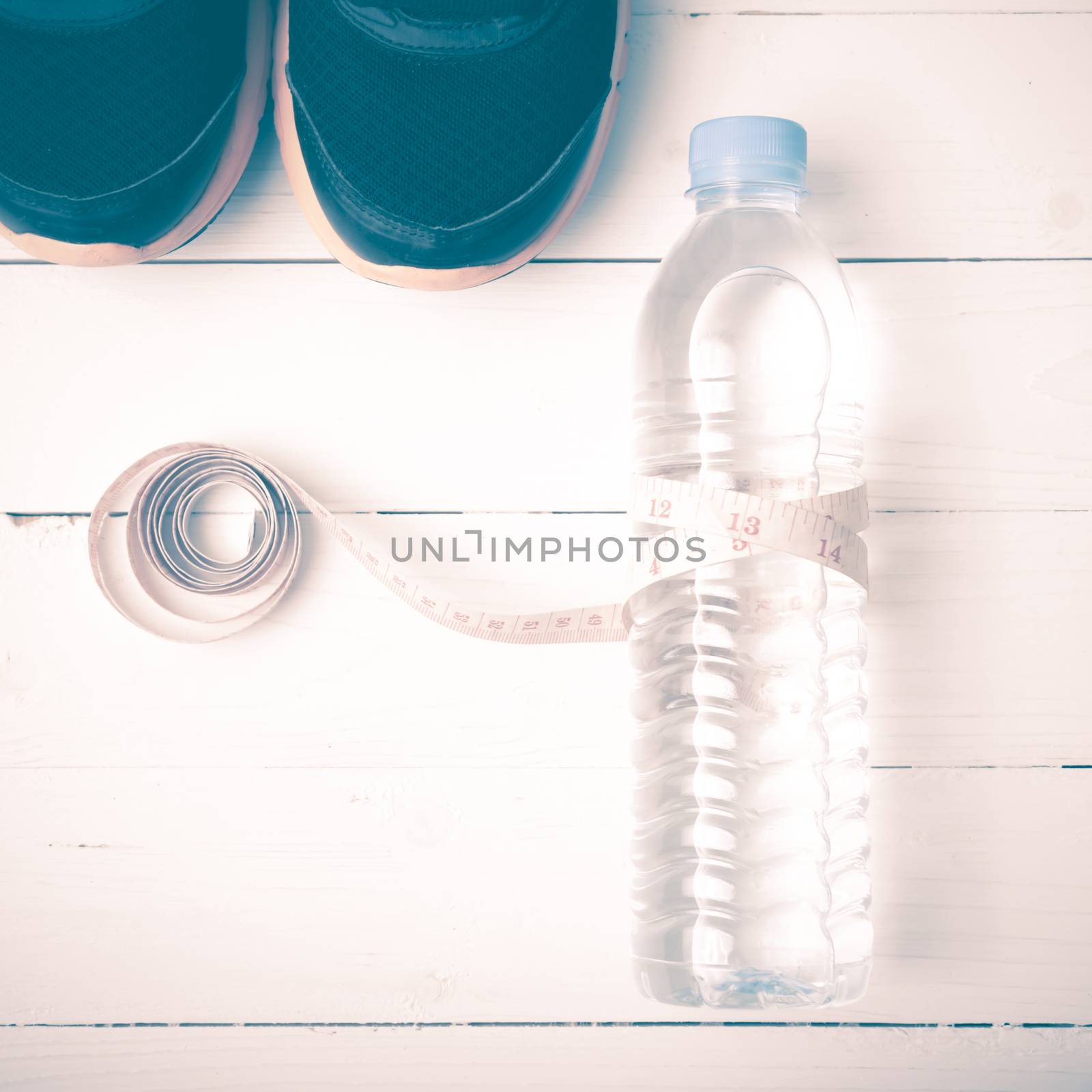fitness equipment : running shoes,drinking water and measuring tape on white wood table vintage style